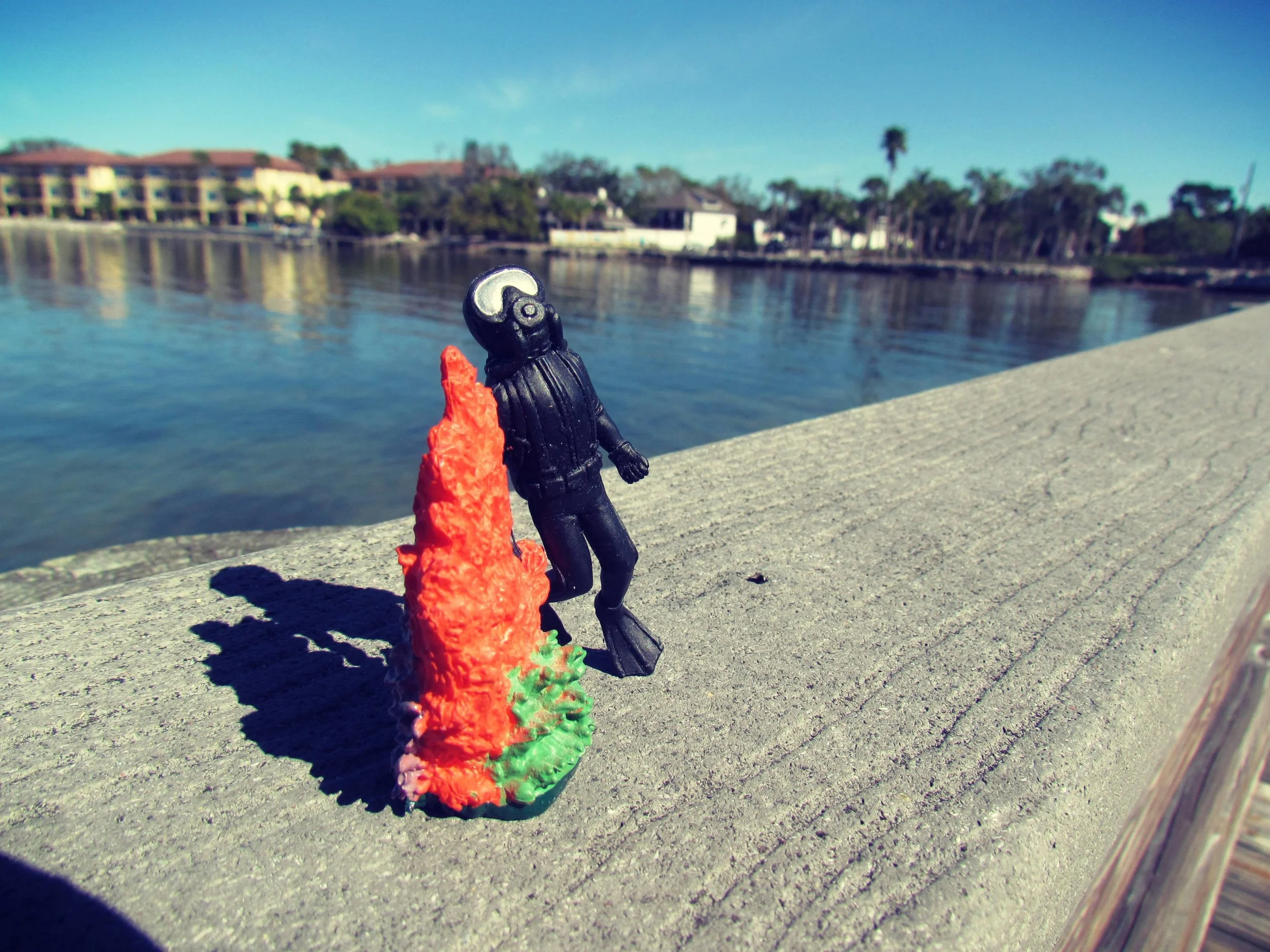 A tiny scuba diver figurine overlooking the ocean from the docks