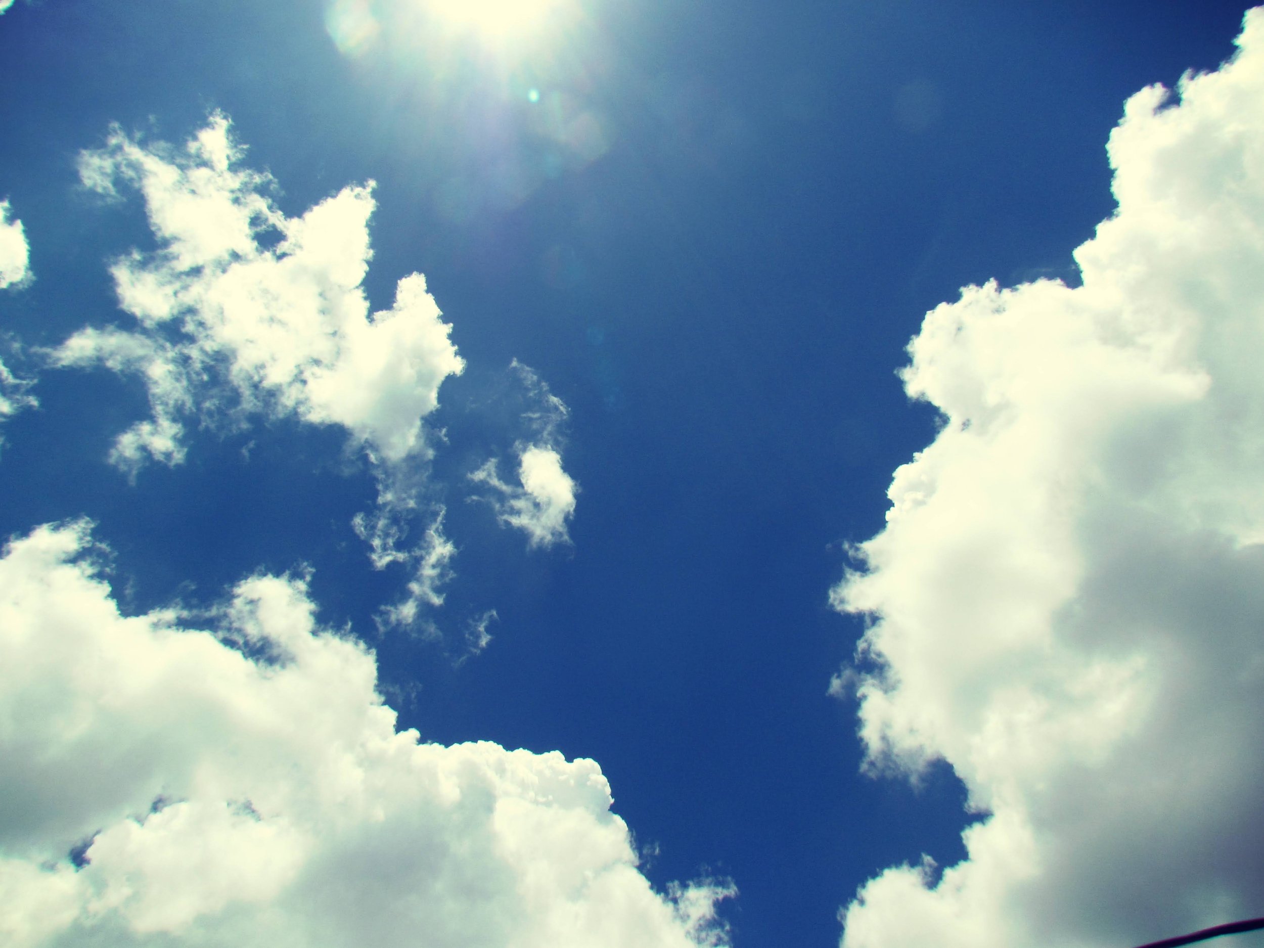 Deep blue skies in the summertime with heart-shaped clouds