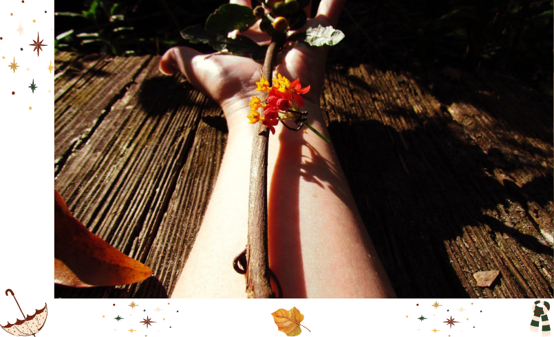 An outstretched arm with nature-inspired artwork branch and flowers