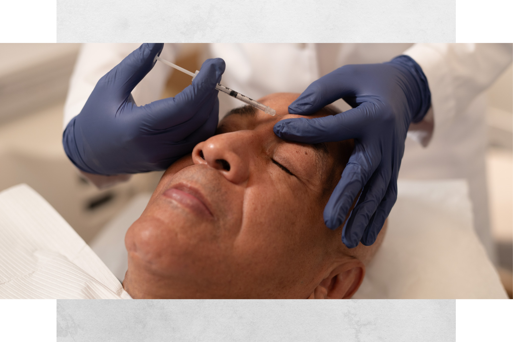A person receiving a cosmetic injection on the forehead from a healthcare professional wearing blue gloves.