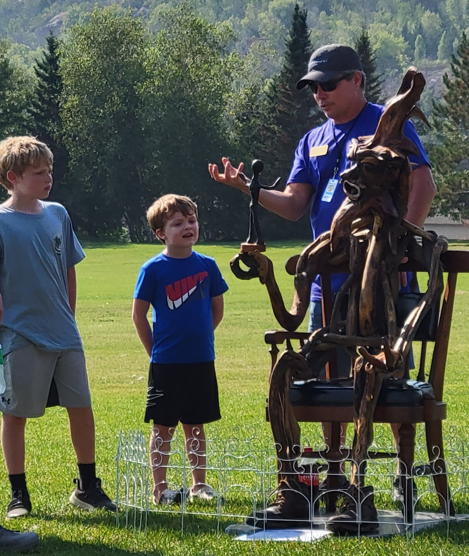 The artist (Wilmer Roballo) discussing his sculpture with some young visitors.