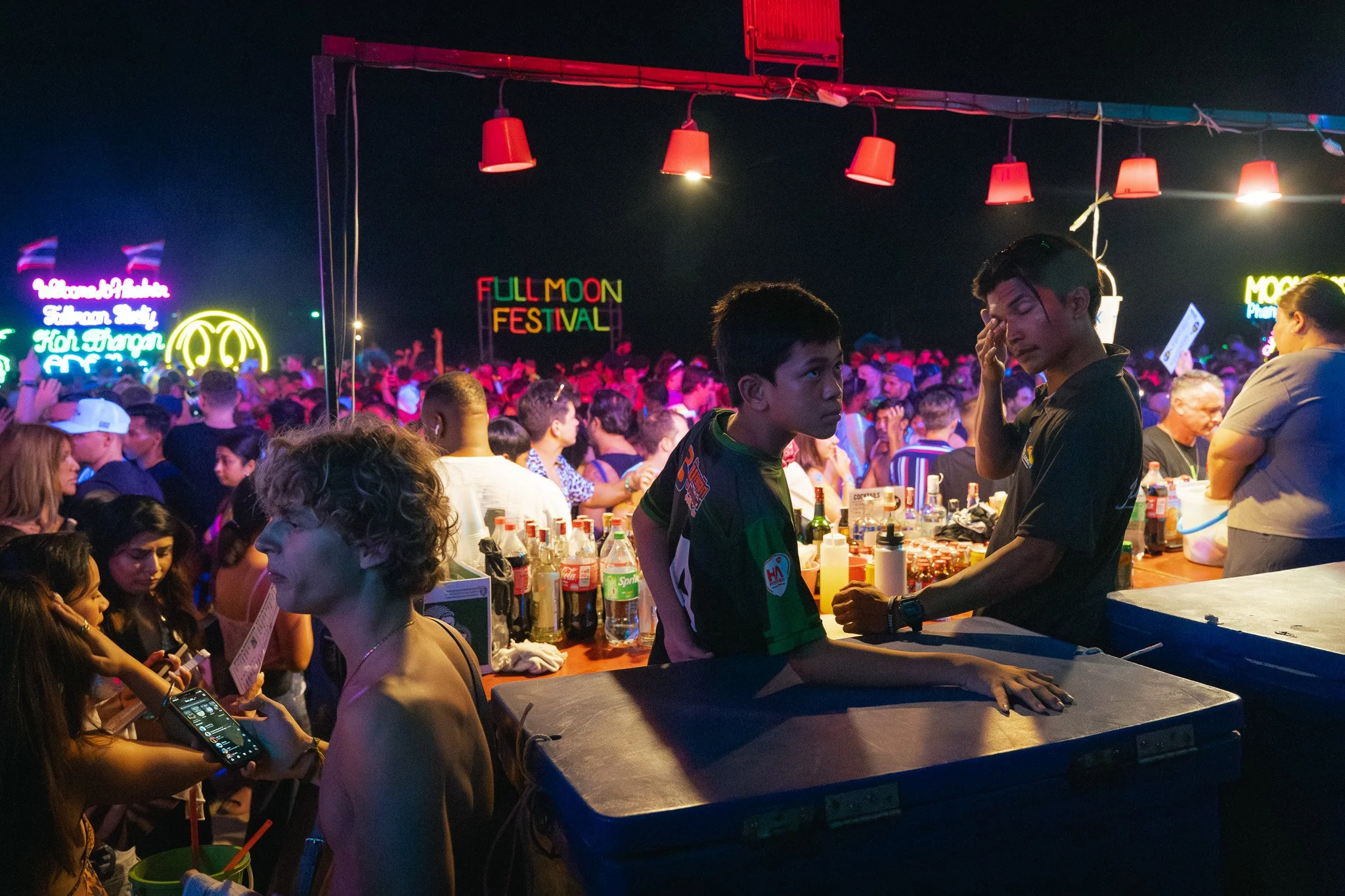 Young Thai bartenders await their next order behind the informal beach bars on Haan Rin beach.
