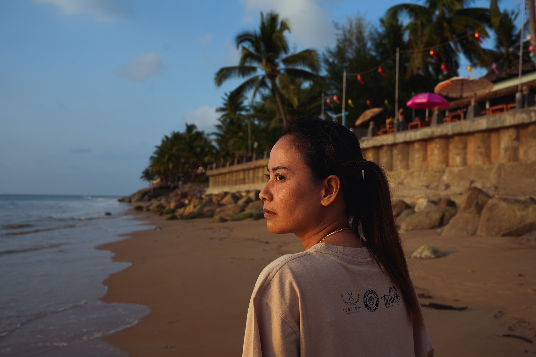 Punticha Nuanyai gazes out at the sunset on Khao Lak Beach which was badly by the 2004 Tsunami. The receptionist says that she used to work at a hotel directly on the beachfront, but now rarely ventures close to the ocean. Shot for The Telegraph (Kha