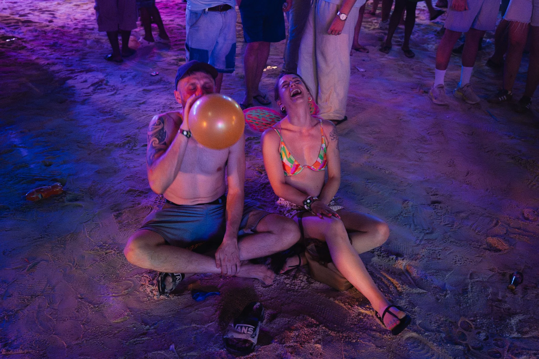 A couple laugh hysterically after inhaling a balloon of nitrous oxide, also known as laughing gas.