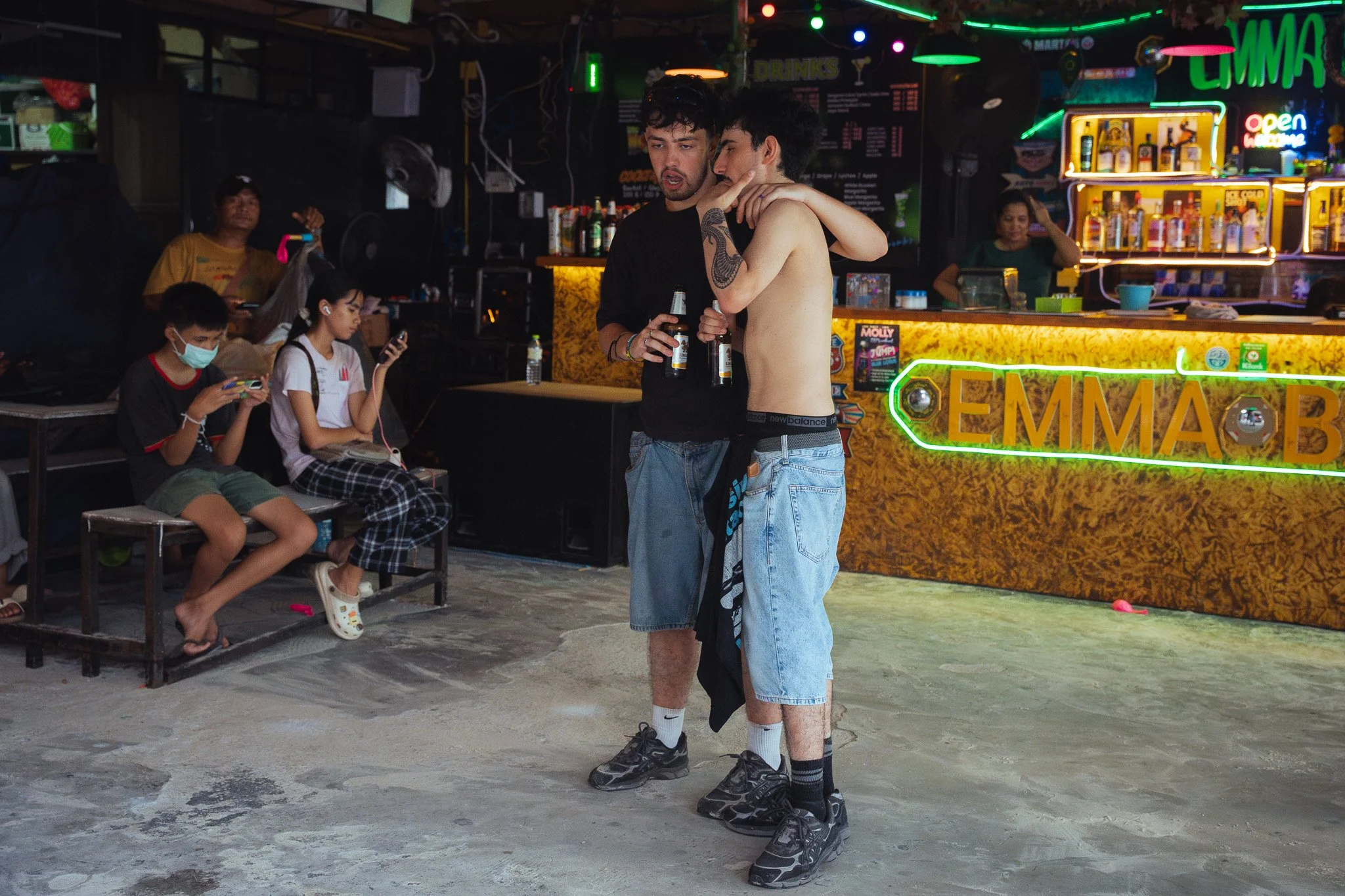 Two men share a slurring conversation at dawn in a beach bar on Haan Rin beach.