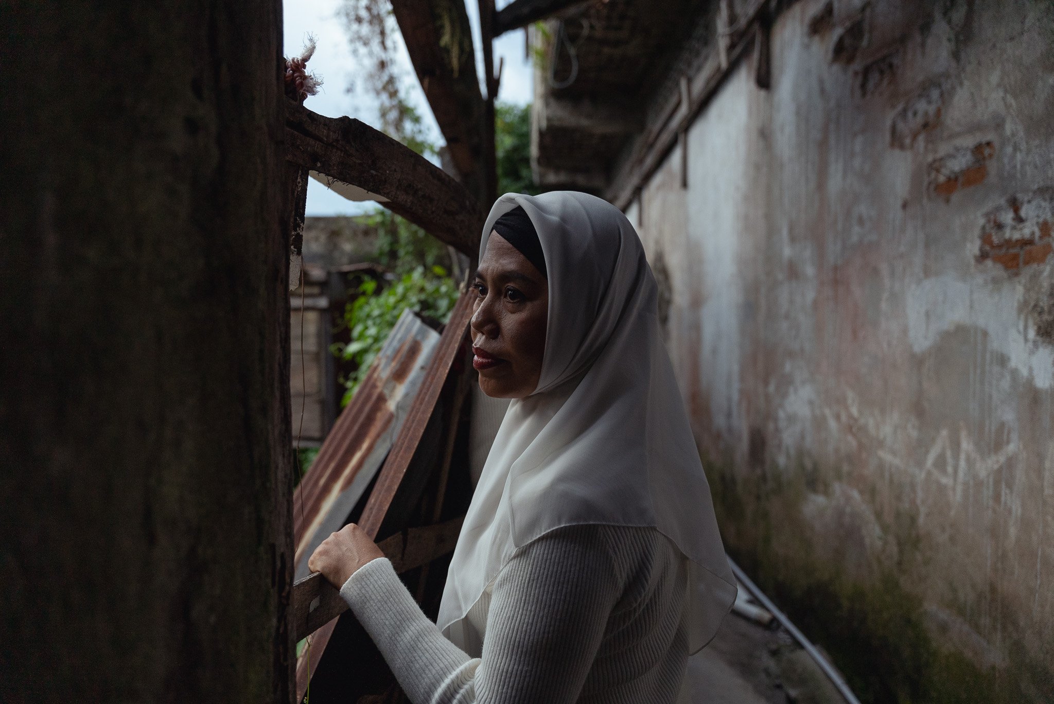 Ela Lamasituju, an activist and peacebuilder poses for a portrait in a dilapidated building which was burned during the Poso Conflict and never rebuilt, shot for UN Women (Central Sulawesi, Indonesia)