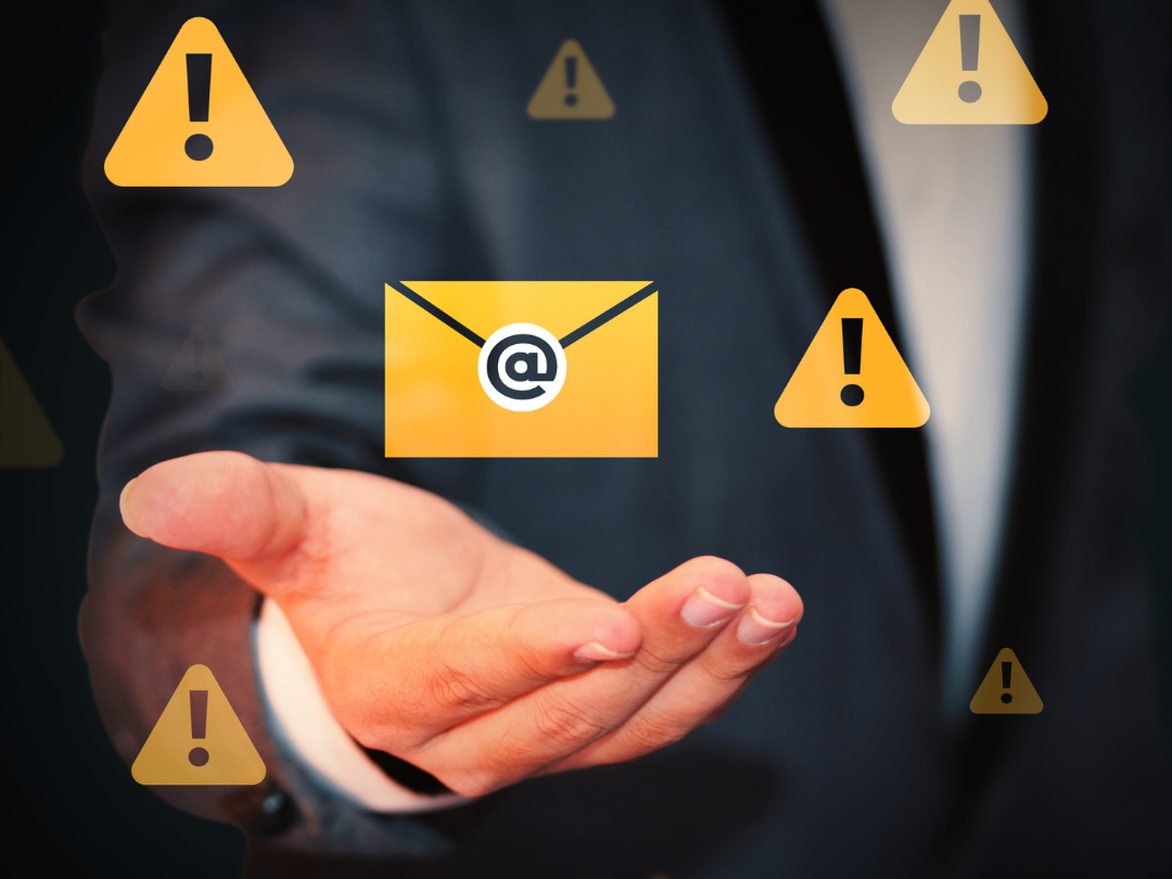 Business man with open palm, warning and email icons hover above open palm in the background