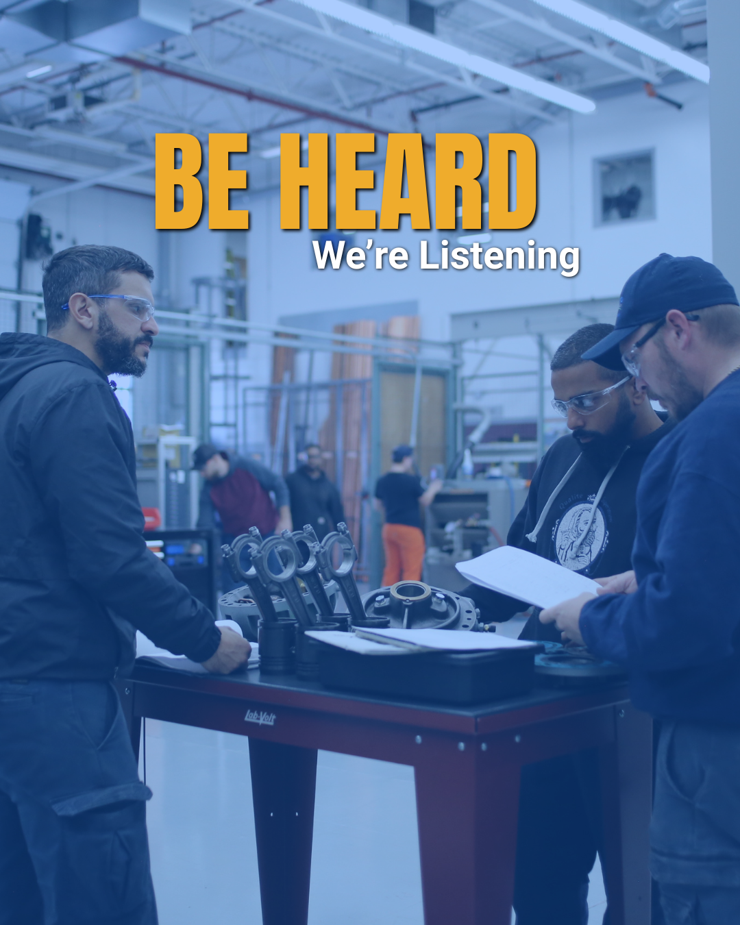 UA Local 787  & Members work on a table over tools, the text overlays read " BE HEARD We're Listening"