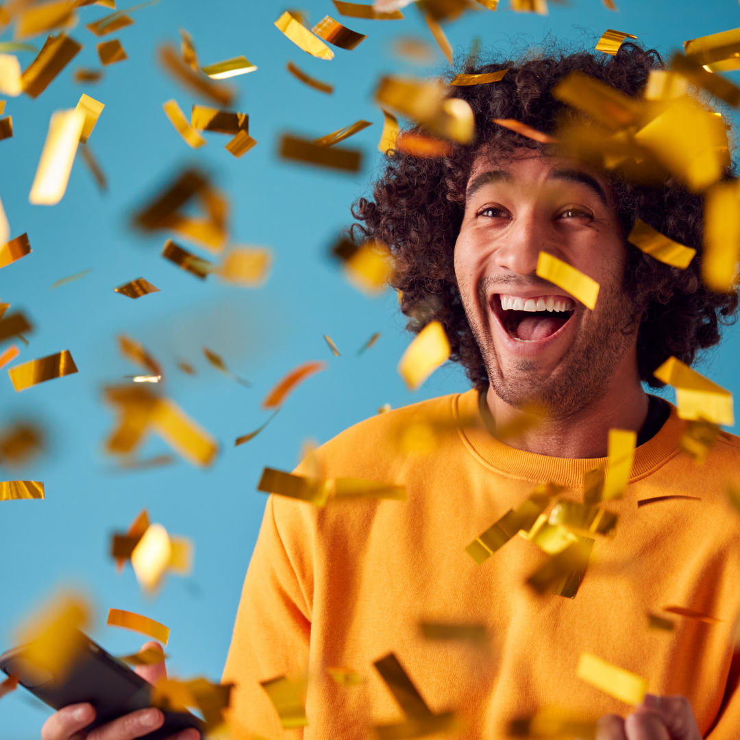 Joyful person smiling wide as gold confetti falls