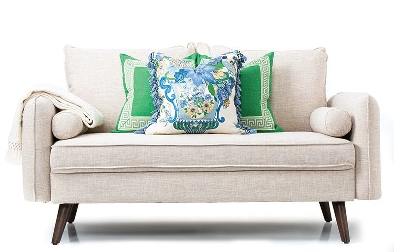 Beige sofa used for home staging with decorative cushions and a throw blanket.