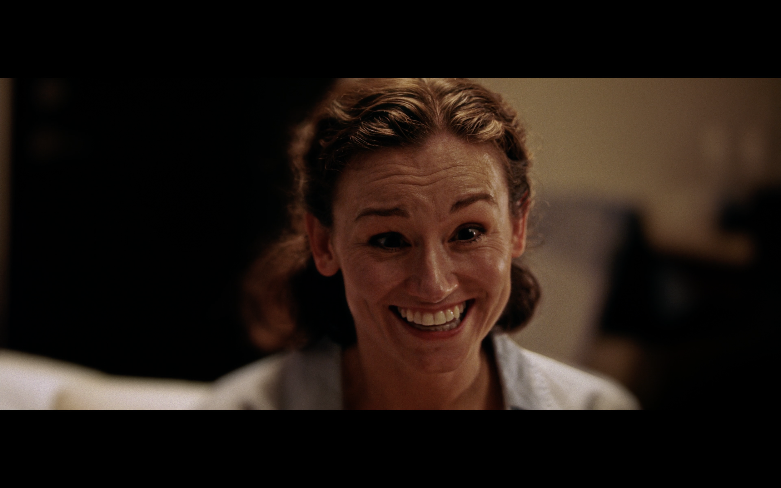 Close-up of a woman smiling with an expressive and joyful facial expression.