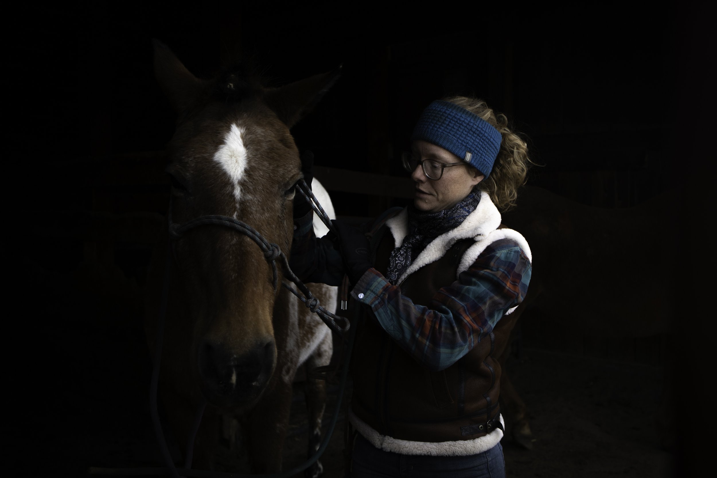  Jessica Seifert calmly strokes a horse in a stable before leading him to a trailer on Nov 15, 2022, at Philmont Scout Ranch in Cimarron, N.M. Seifert is often asked about her role as the only female ranch technician. “It doesn't make me feel like I'