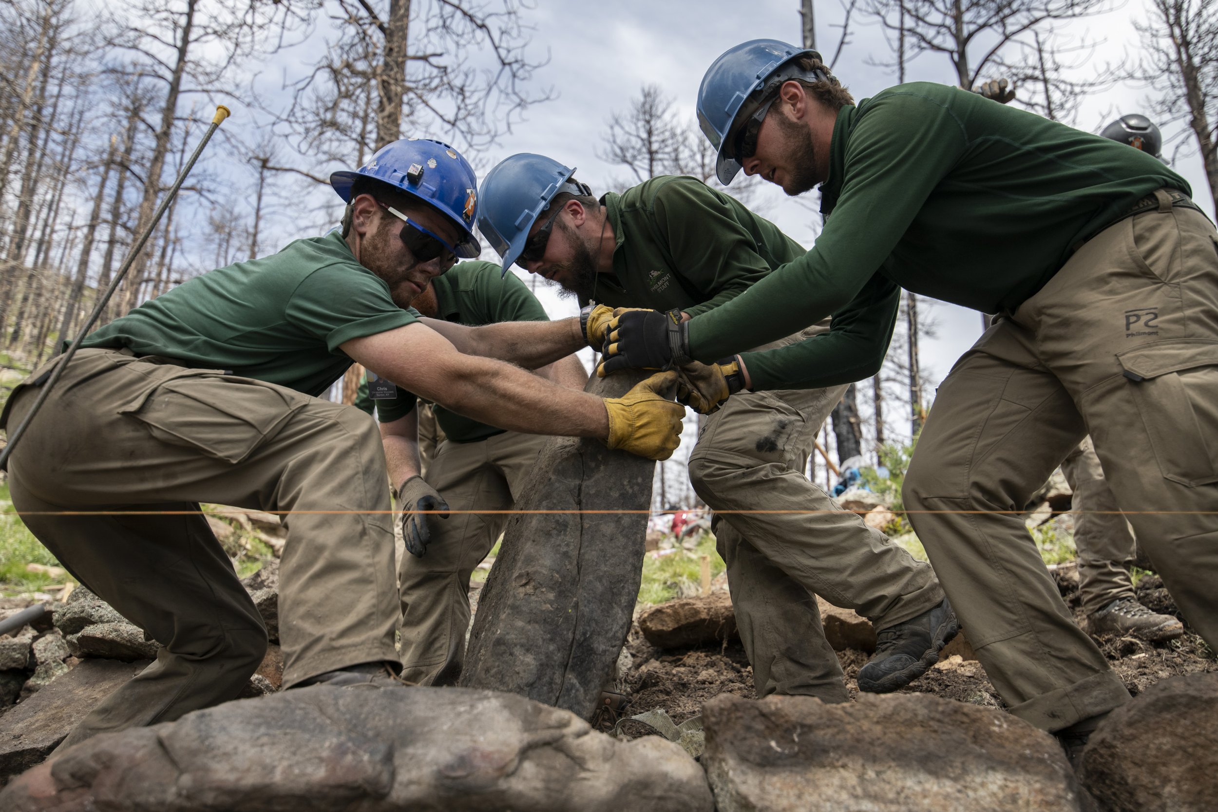  From left, conservation staff members, Chris Shoulders, Nick Burns, Karson Wilson, Brendan Horan, and Gabe Cash lay a cap rock on a newly built trail at Cimarroncito on Philmont Scout Ranch, N.M. on June 2, 2021. With a total of 120 staff members, t