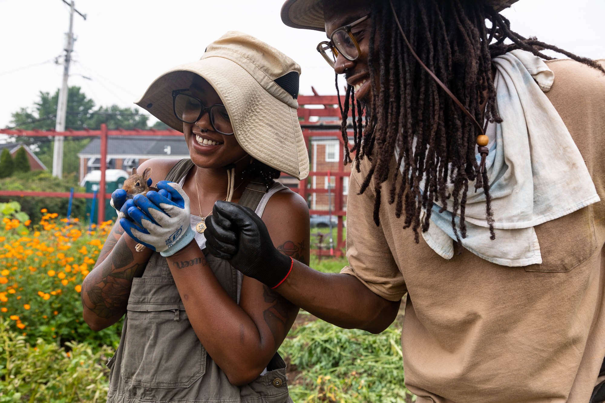  Saj Dillard shows Jordan Bethea a baby rabbit she found roaming the grow space at BLISS Meadows in Baltimore, Md. on July 17, 2023. Before working at BLISS, Dillard spent little time outside; her advice for people like her was, “Get outside, hug a t