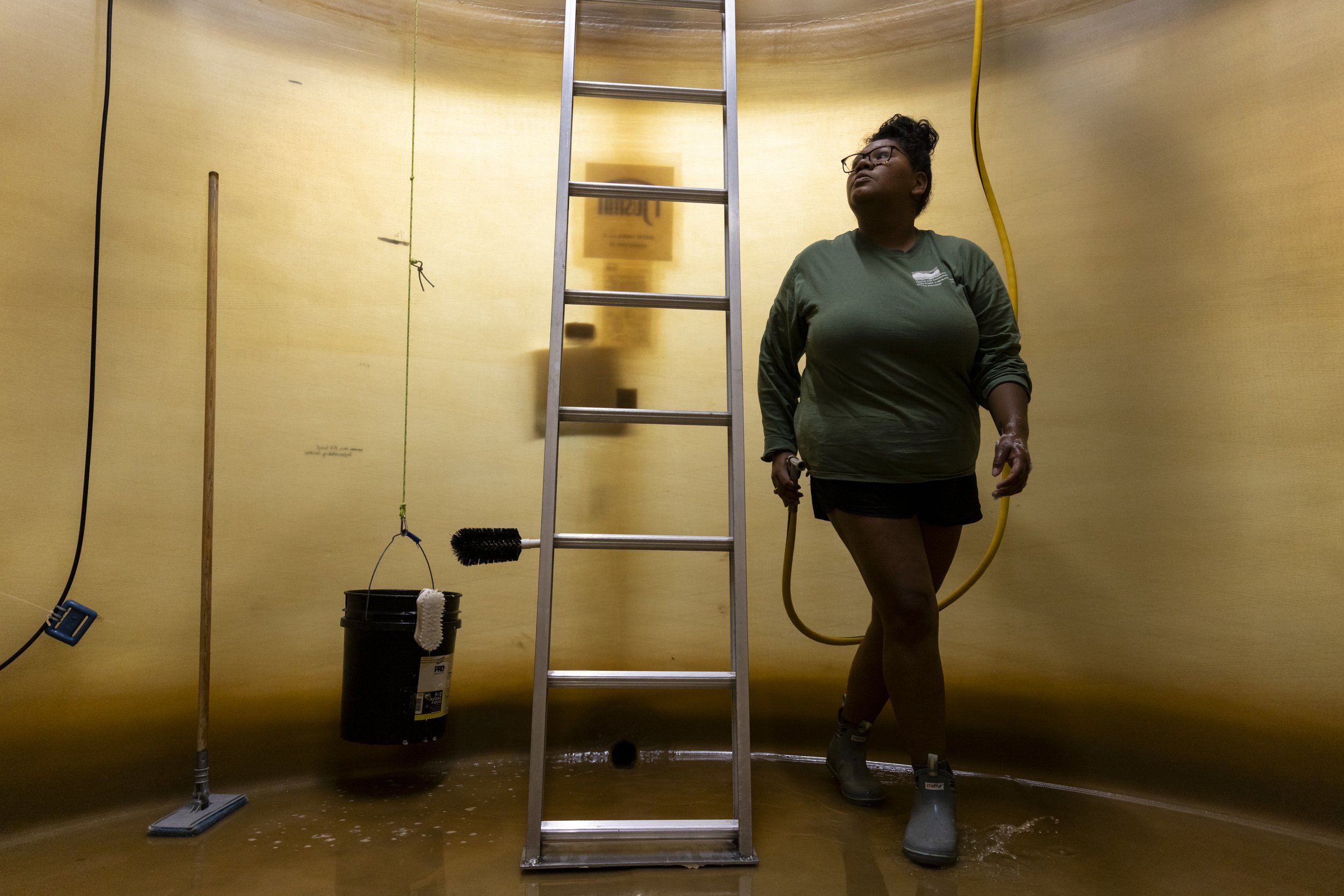  Makayla Lloyd, an intern with Minorities in Aquaculture (MIA), cleans a mass larvae tank at Horn Point Oyster Hatchery in Dorchester, Md., on Aug. 4, 2023. Lloyd found a deep love for oysters after being mentored by MIA founder, Imani Black. The org