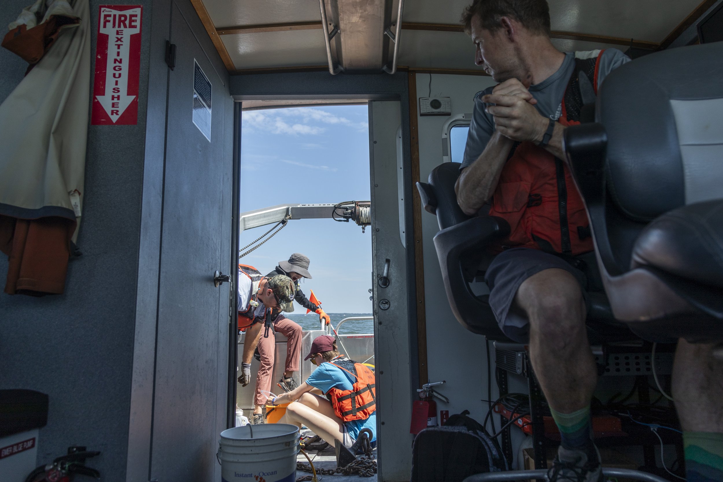  A team from the National Oceanic and Atmospheric Administration (NOAA), alongside interns, work to retrieve a hypoxia buoy that is connected to sensors along inductive wire at the mouth of the Choptank River near Talbot County, Md., on June 27, 2023