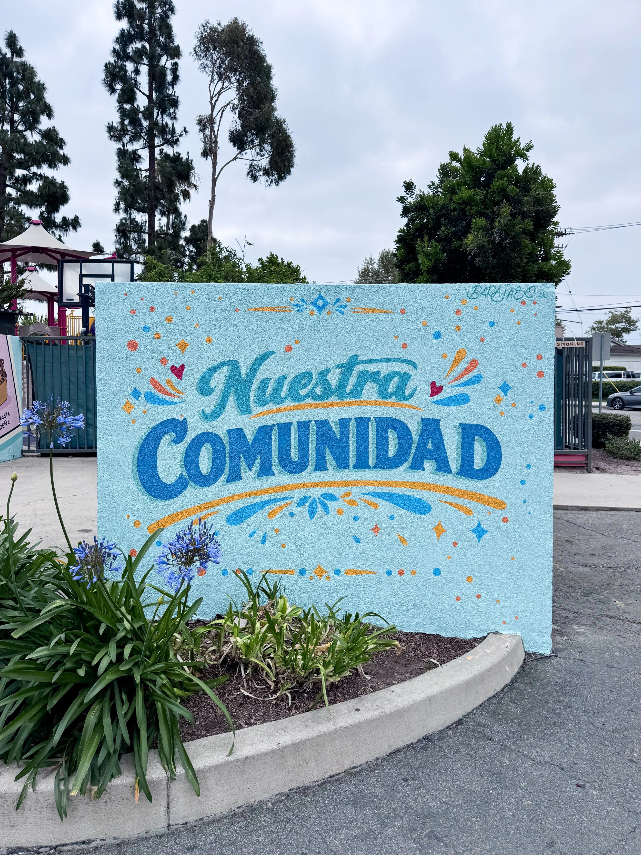Nuestra Comunidad Straight enclosure wall · 8' × 5.5', acrylic on stucco with an anti-graffiti coating.