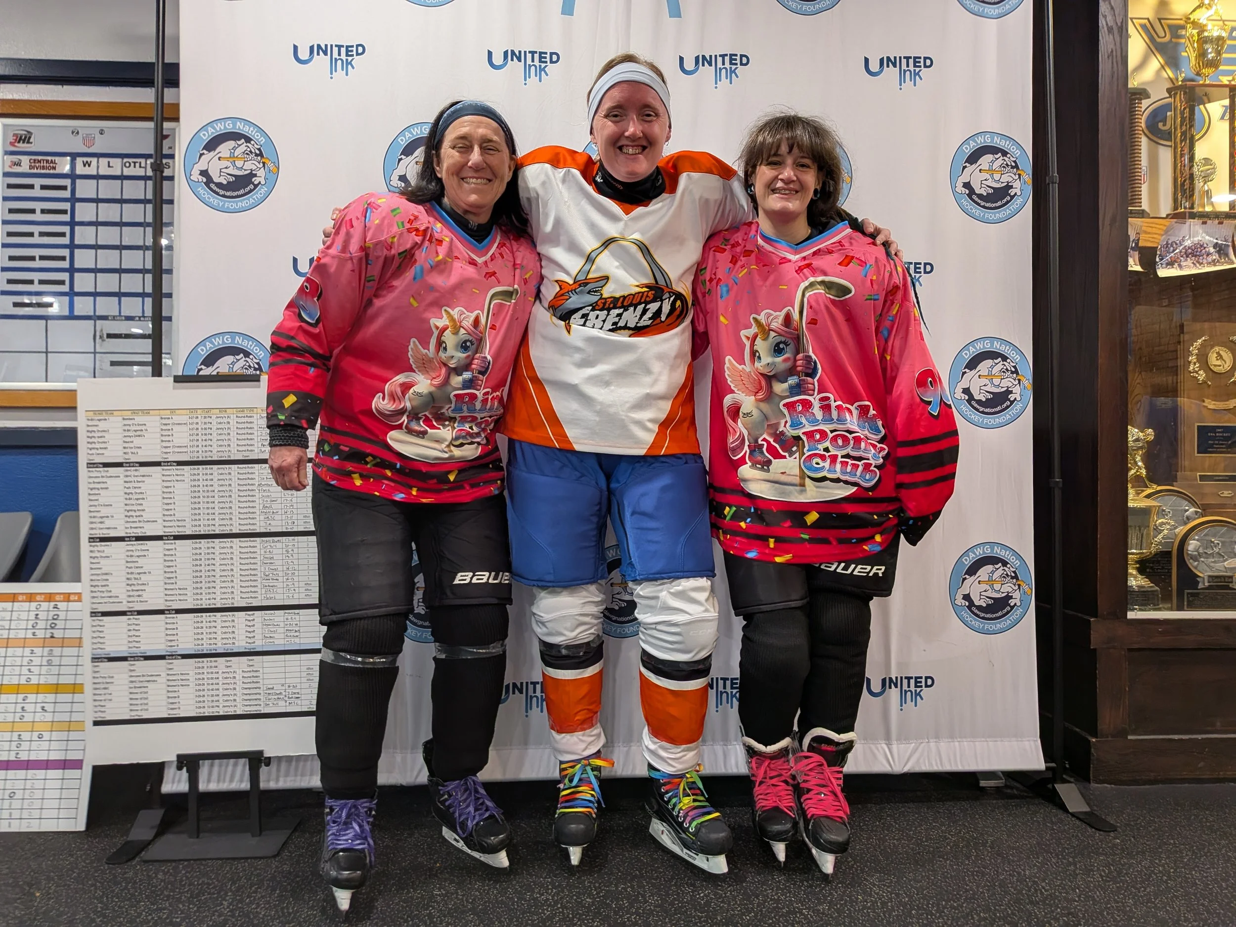 Three woman wearing hockey gear and posing together