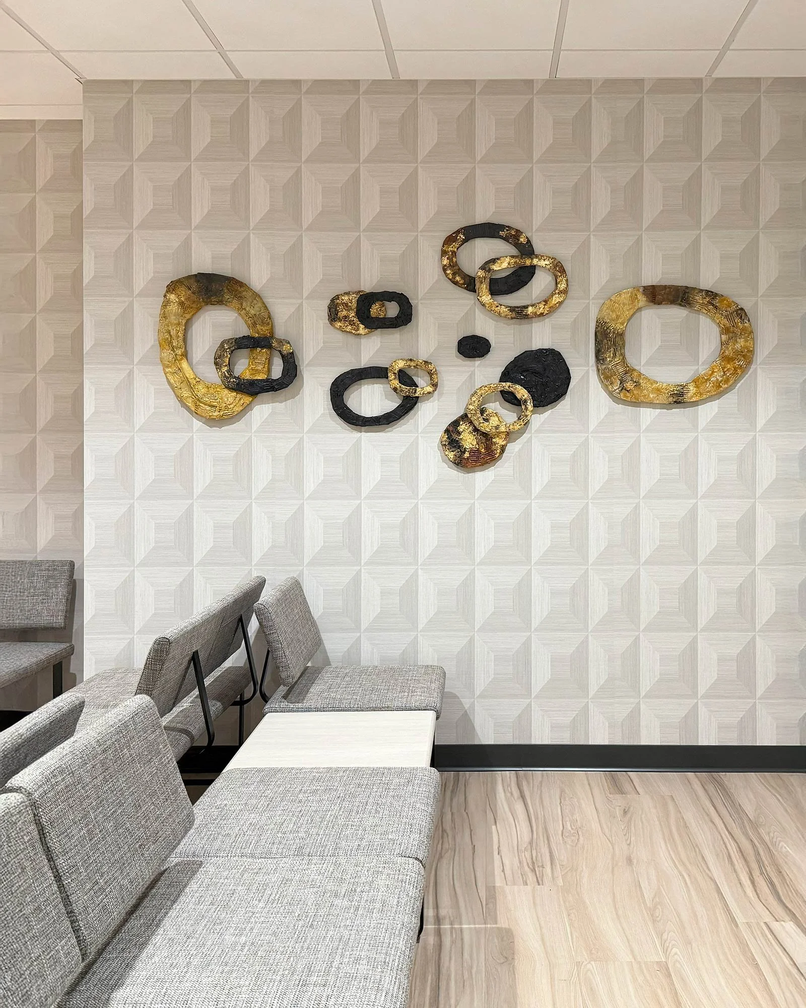 "Shimmer Rings" mixed media wall sculpture - low relief cardboard, acrylic, beaswax, and gold leaf.