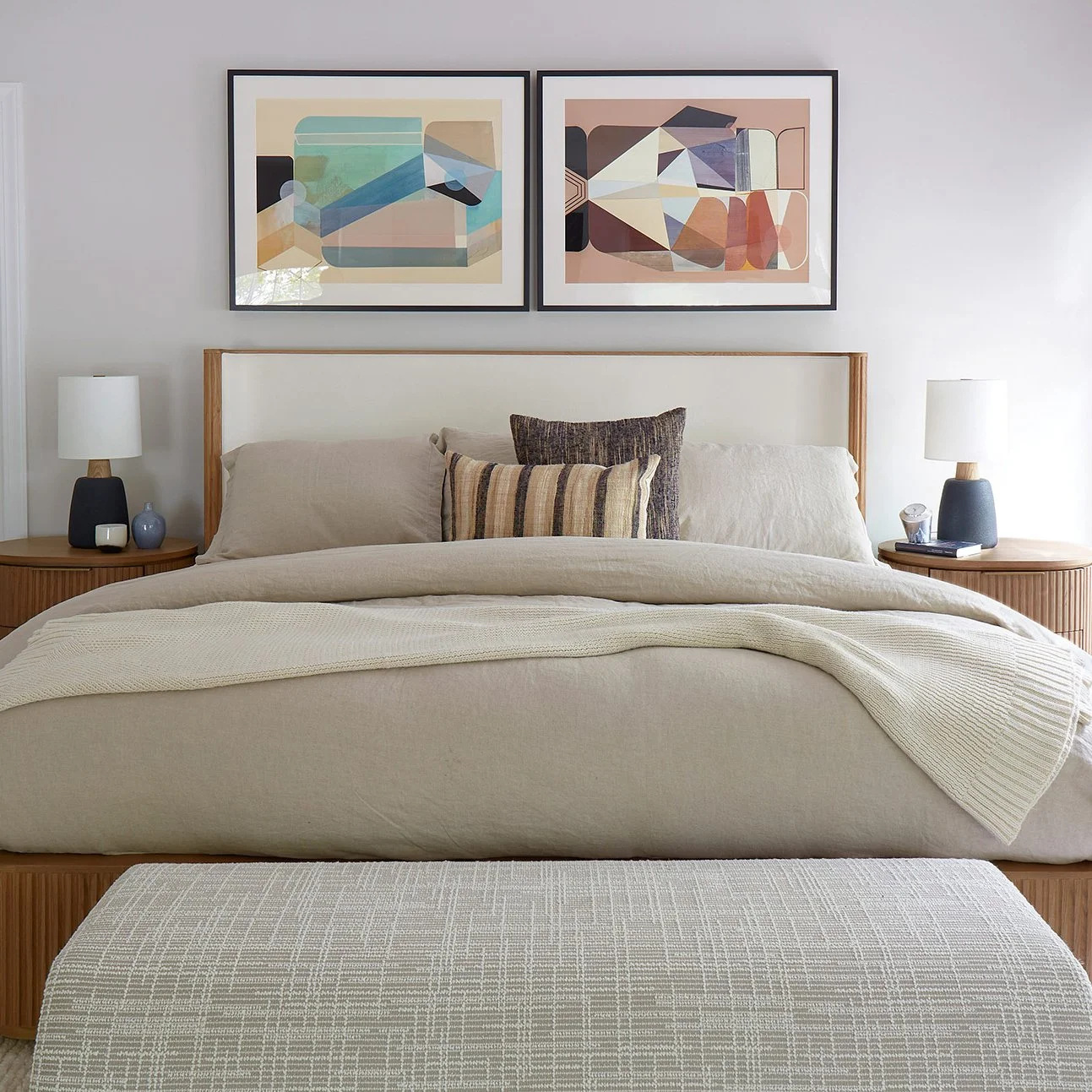 Modern prints in primary bedroom over headboard