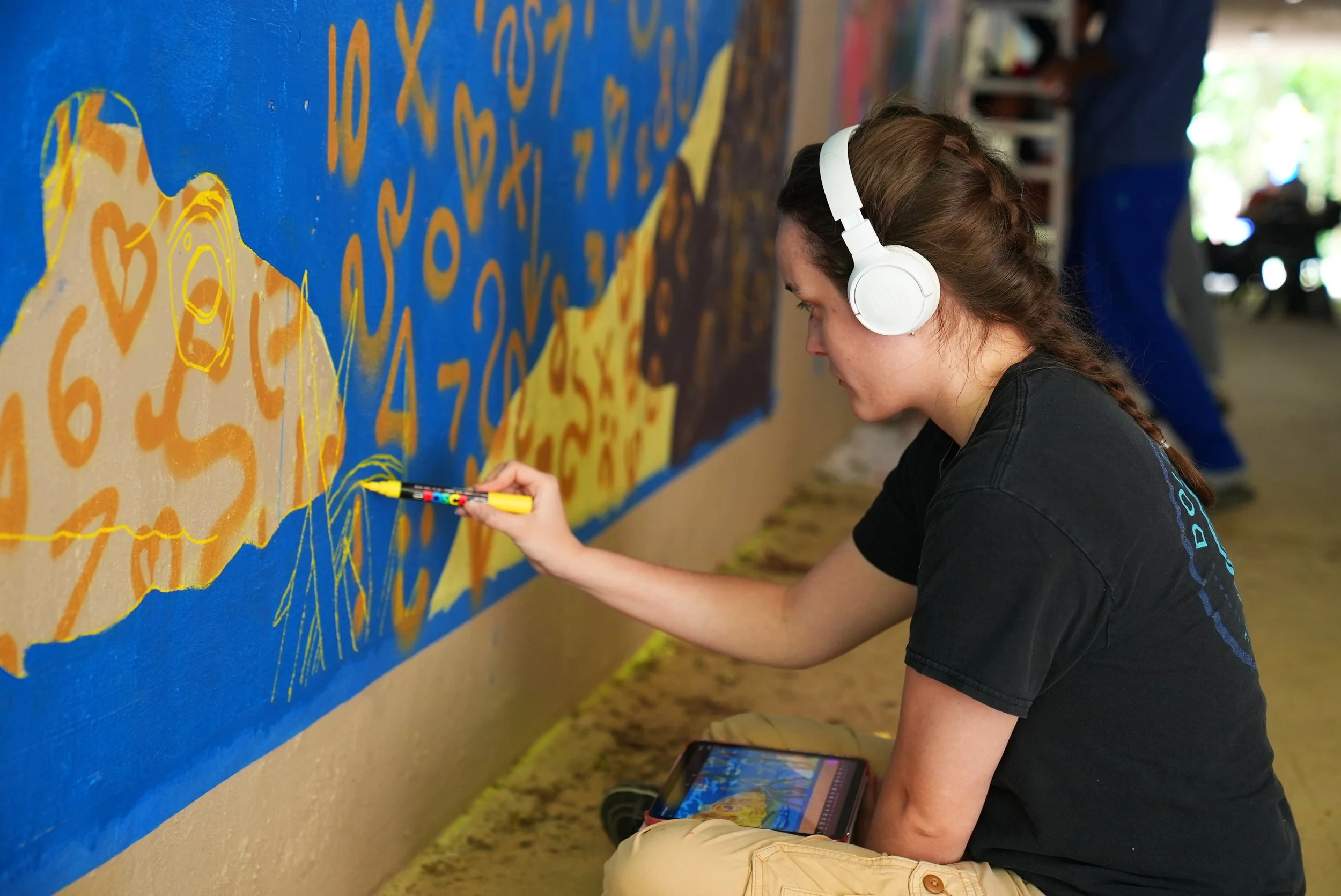 Image of the artist Adele Ferguson working on her mural