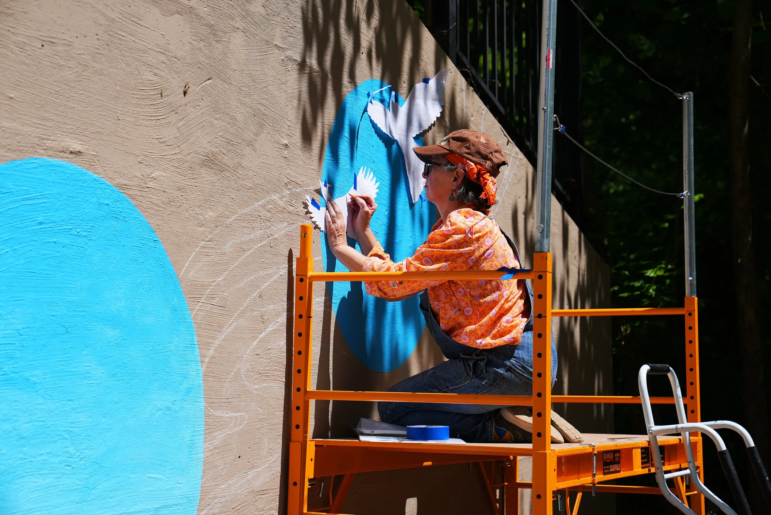 Image of artist Angi Cooper painting her mural
