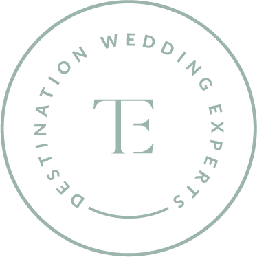 Logo with a circle reading 'Destination Wedding Experts' around a stylized monogram 'T' in the center.