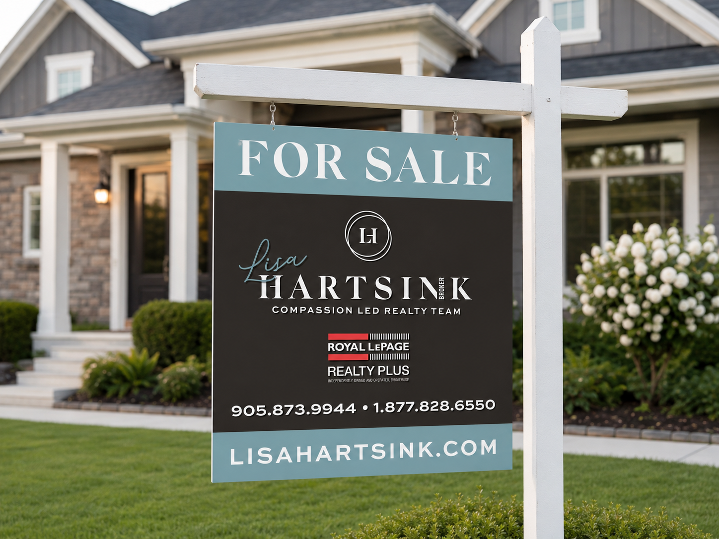 A real estate sign in front of a house advertising it as for sale, with contact information and the realtor's name, Lisa Hartsink.
