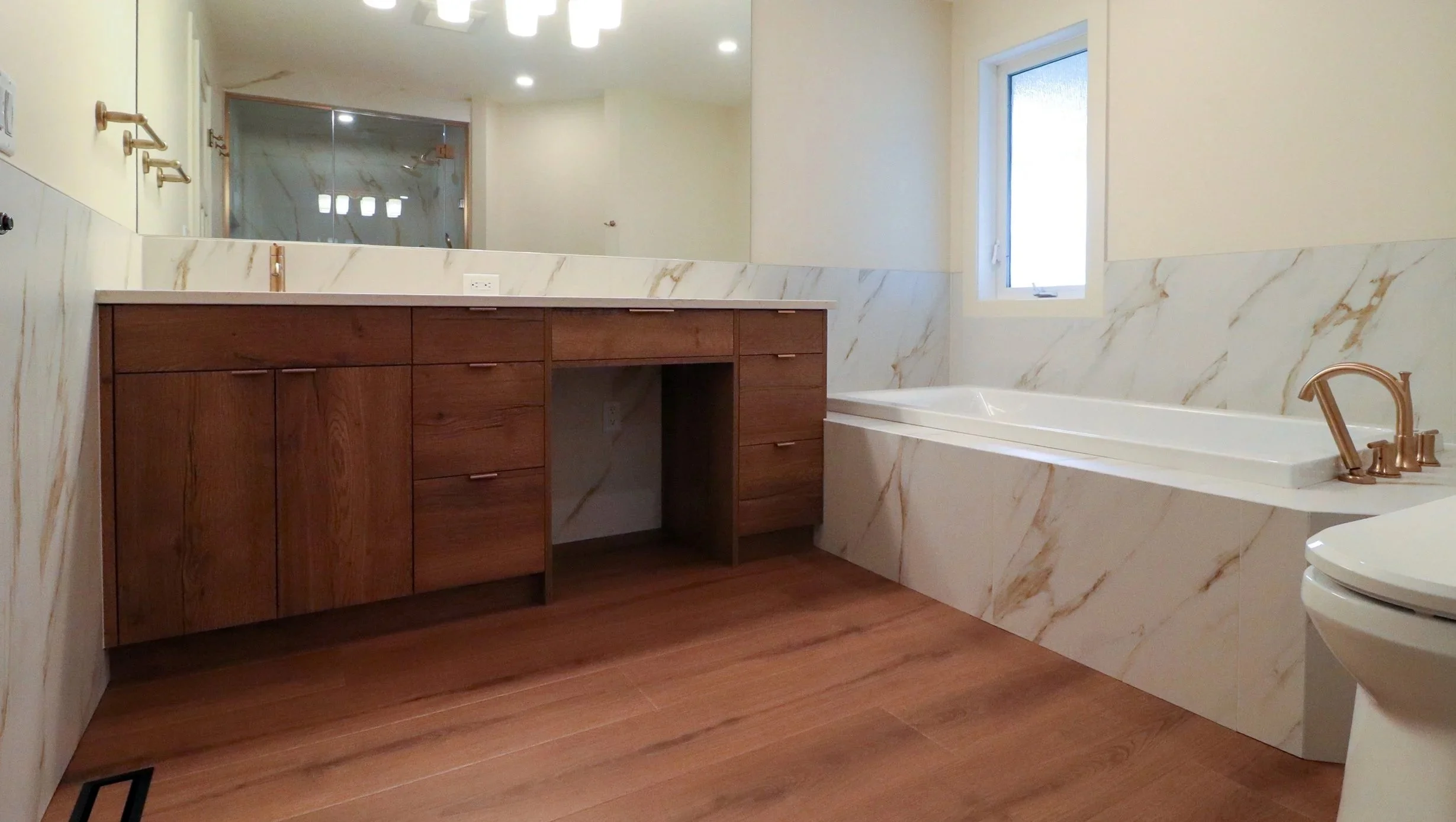 Long wood bathroom vanity with sink and seated niche.