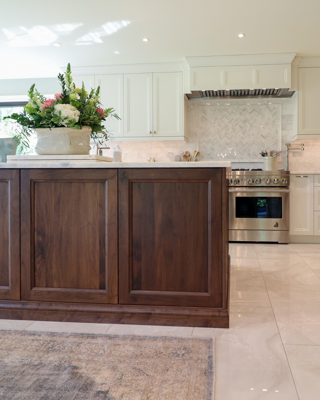 Open-plan white and dark wood kitchen with large central island.