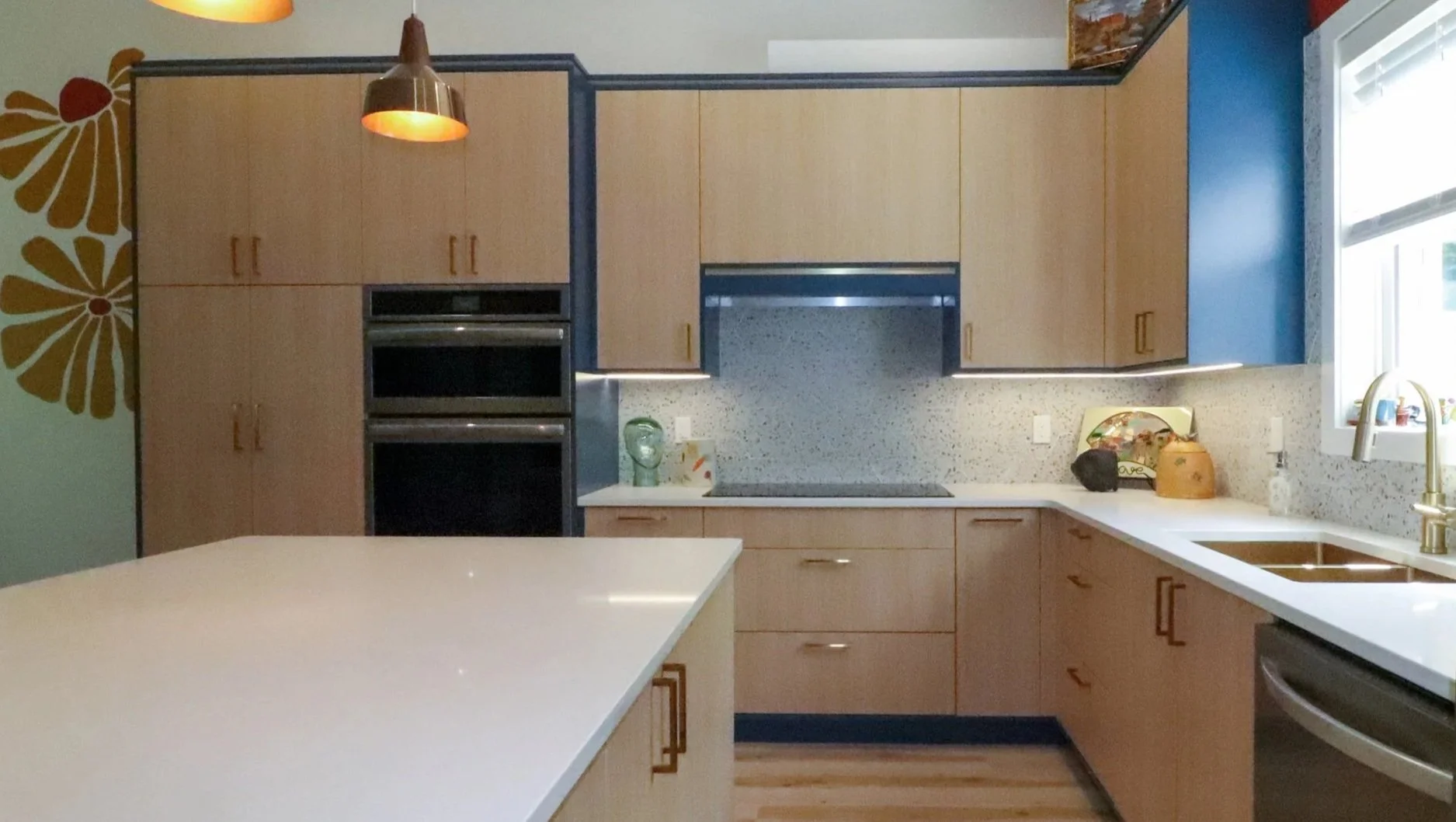 Open kitchen with Kensington Blue island, Vicenza Oak cabinetry and double ovens.