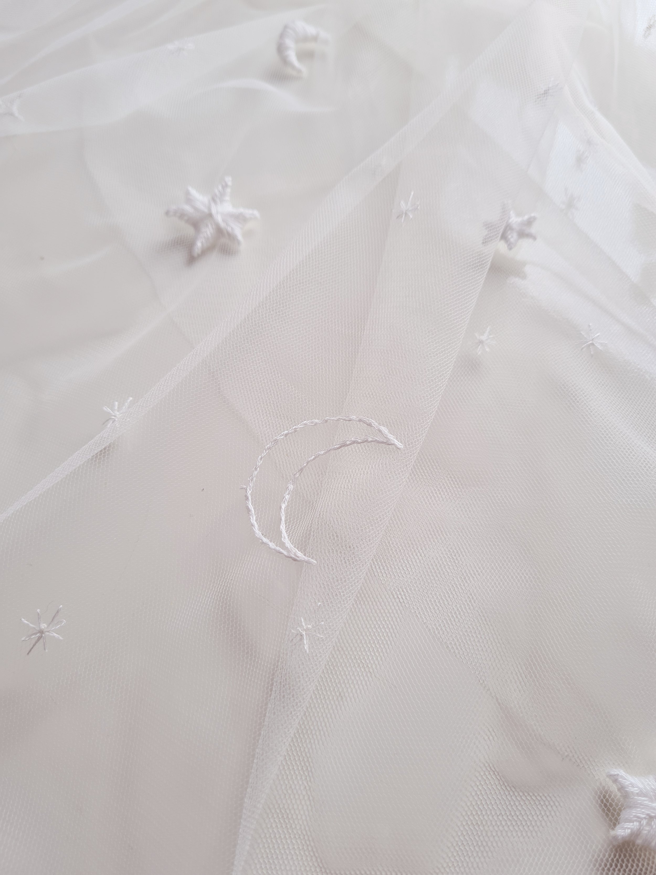 An ivory tulle celestial wedding veil with hand embroidered moon design