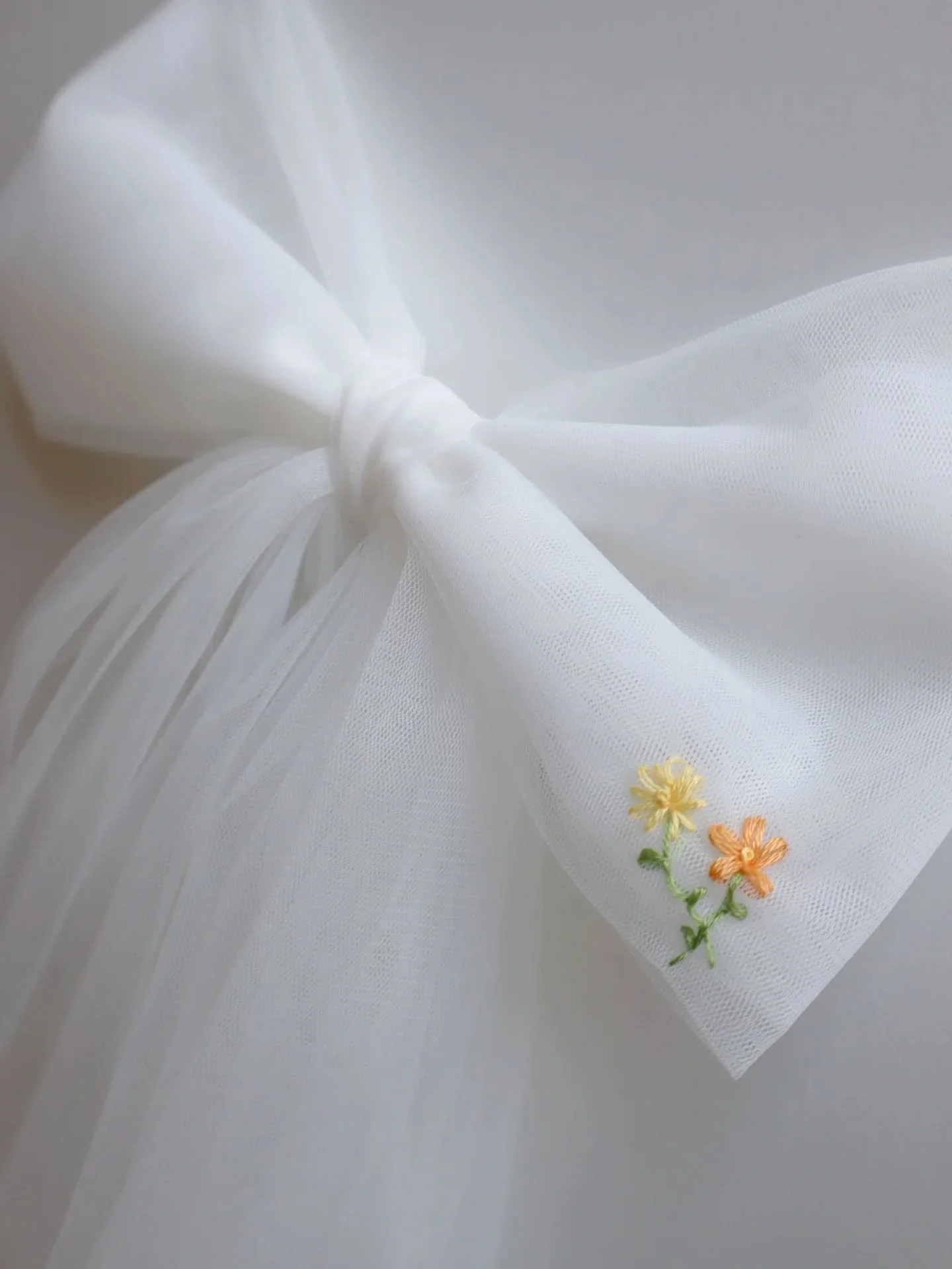 A bespoke floor-length bow for Shelby 💘

Created in our signature Falling Flower style, the hand embroidered flowers start as tiny blossoms before fading into more complex flowers.

Shelby's colour palette was light and fresh with shades of yellow a