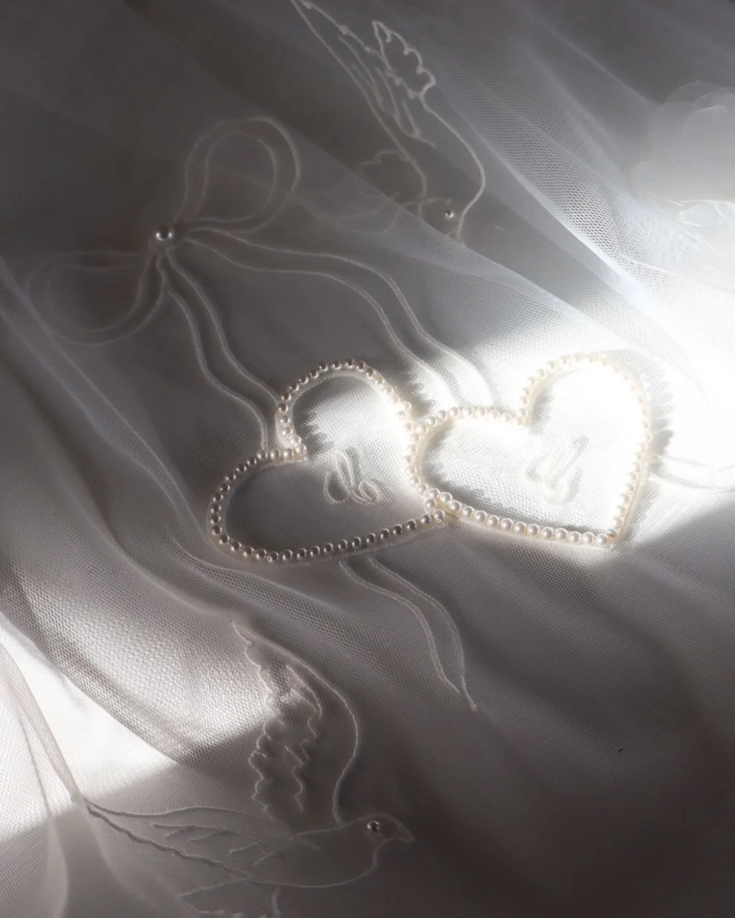 Sunshine falling on a custom version of our vintage ribbon and pearl hearts veil. Created with additional handmade organza and tulle flowers with pearl centre 💘