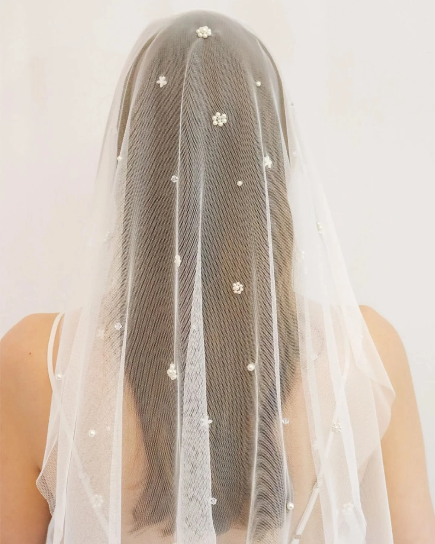 Little pearl beads, hand embroidered into flower shapes, mixed with crystal flowers, single pearls, and threadwork flowers in shades of ivory 🤍 Lots of detail for a wedding veil that is very delicate. Created on soft Italian tulle in our favourite d