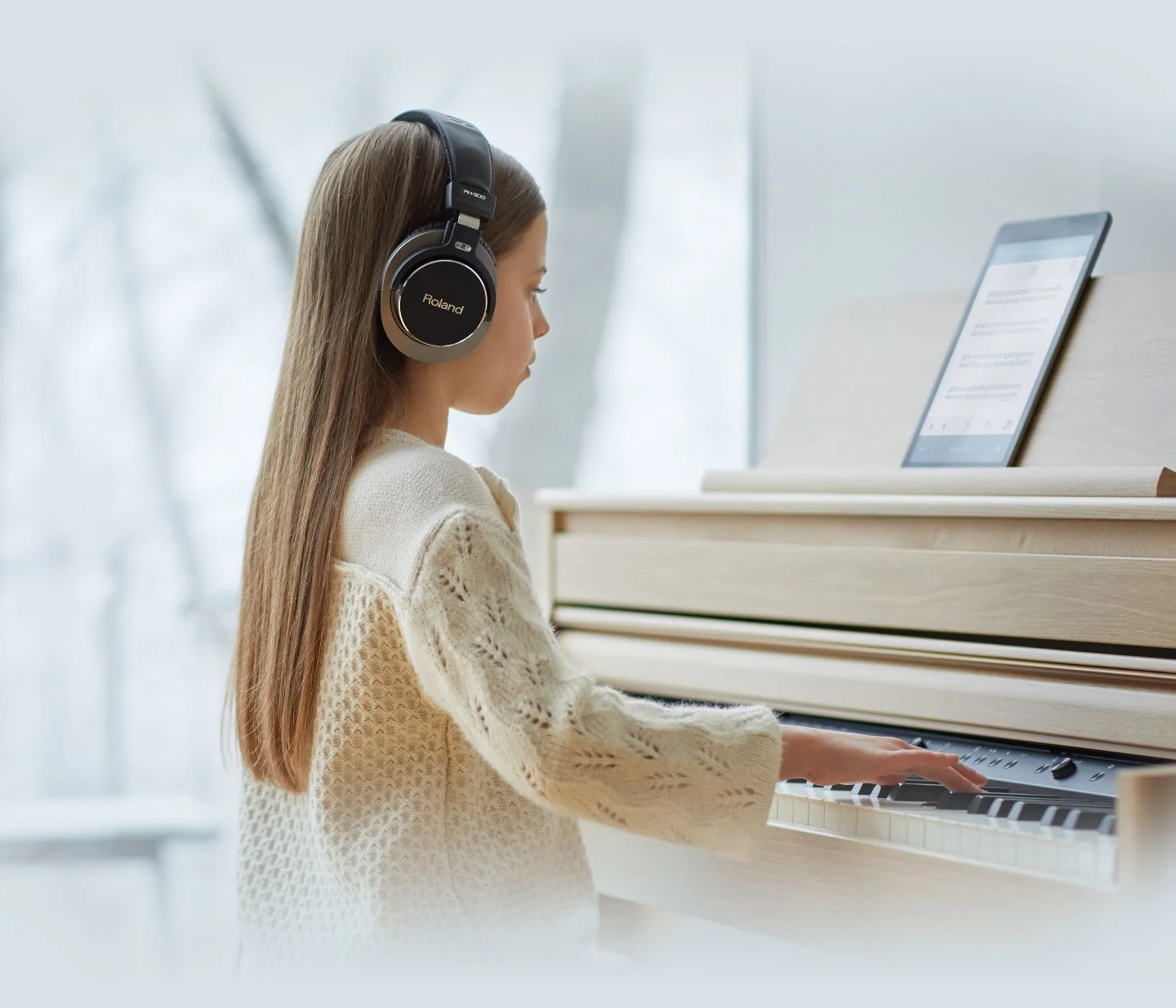 Child using a digital piano with headphones