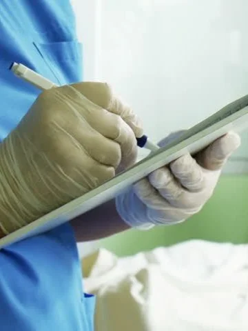 Doctor writing in chart