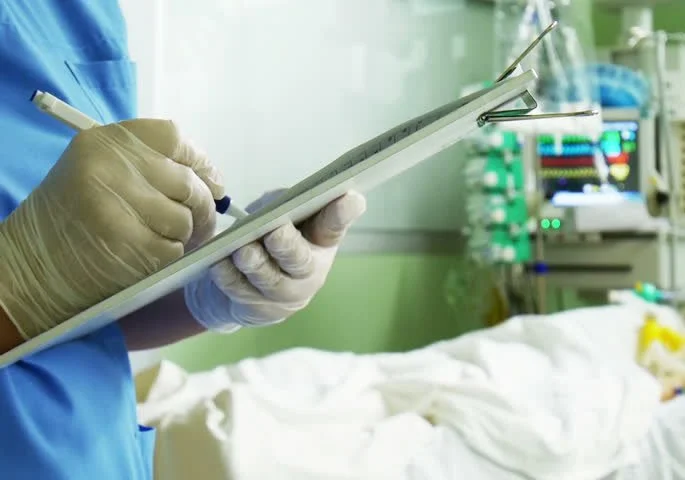 Doctor writing in chart