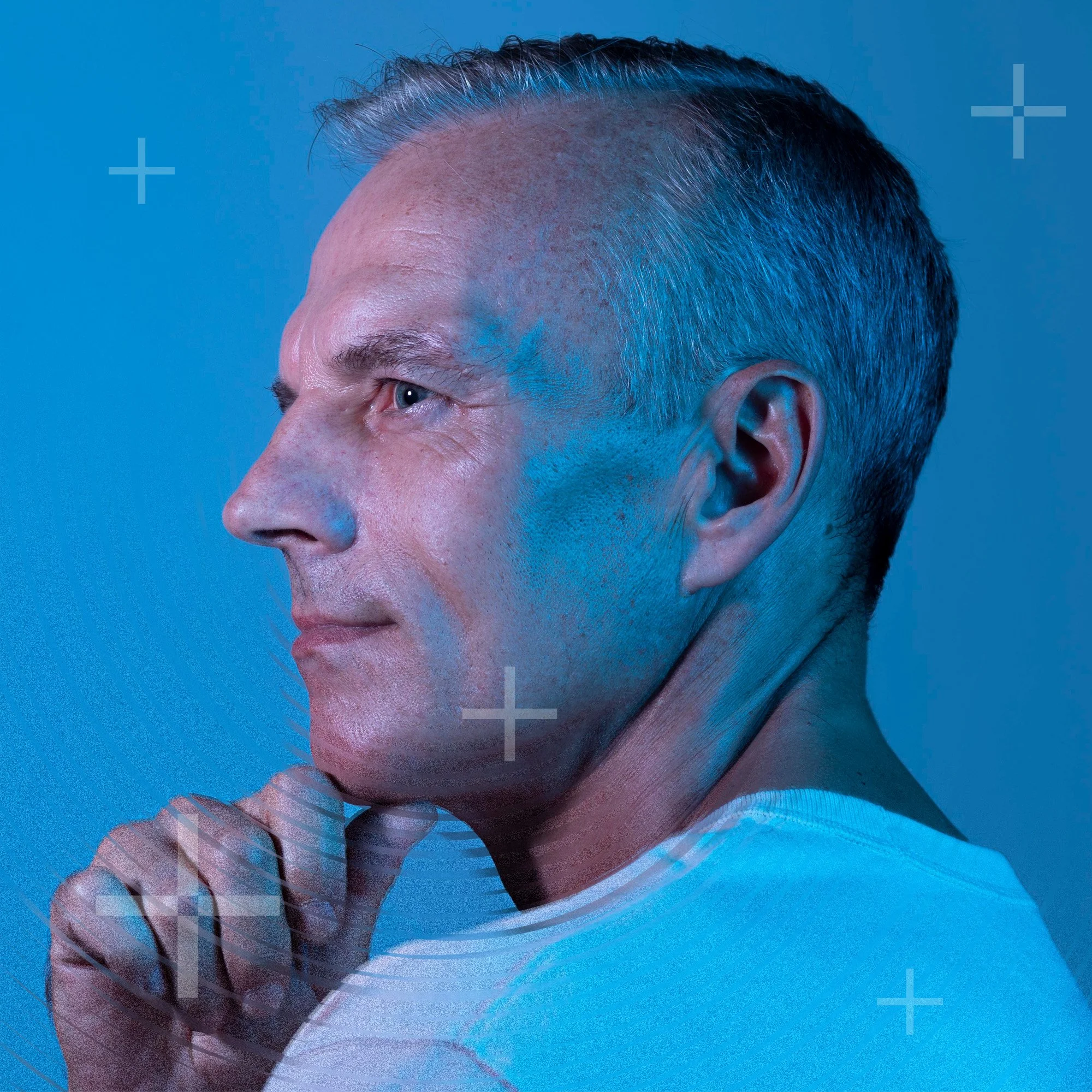 Man looking left pondering with thumb on chin.