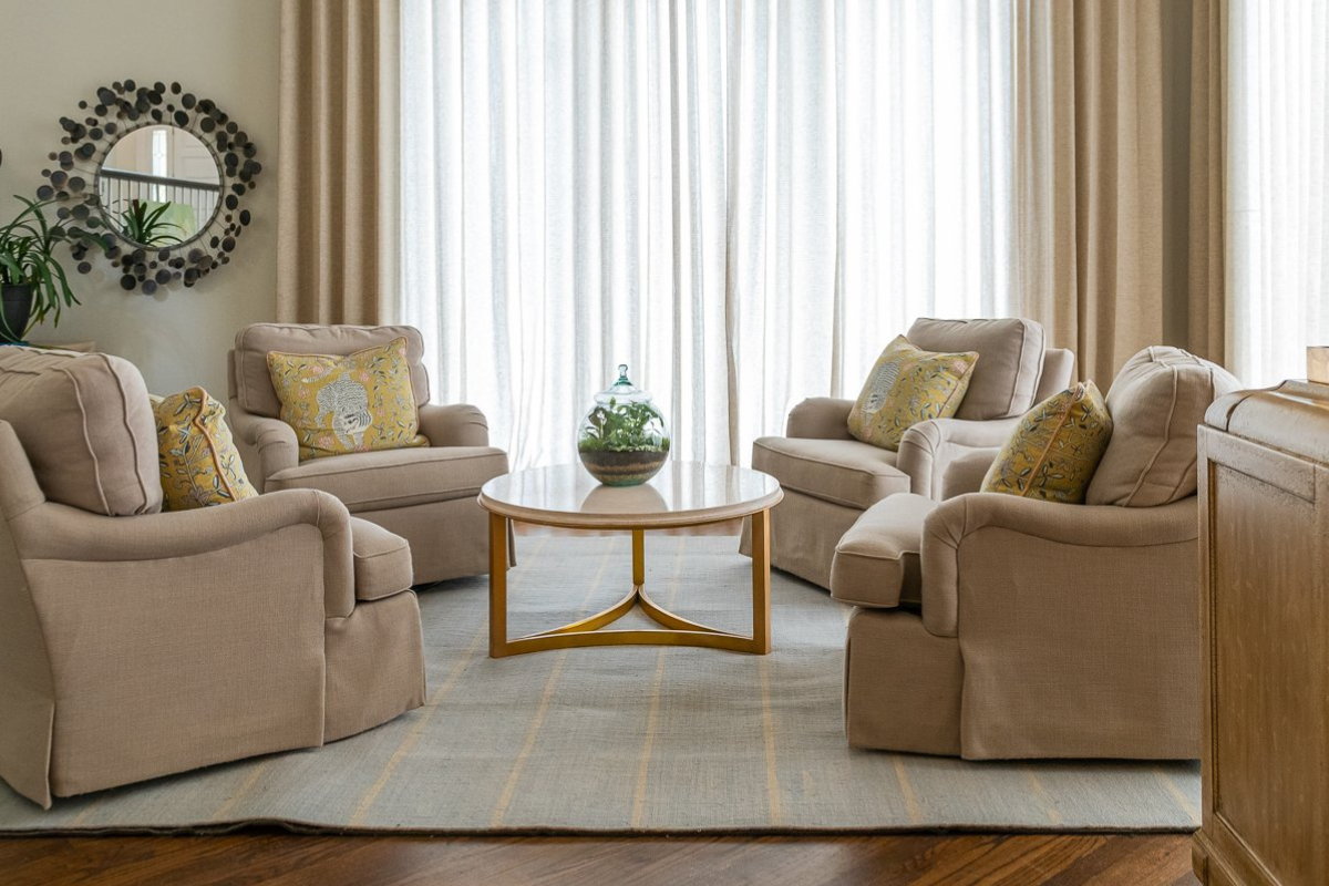 Creamy neutral sitting area with floor-to-ceiling drapery, layered textures, and warm modern furnishings designed by Violet Marsh Interiors