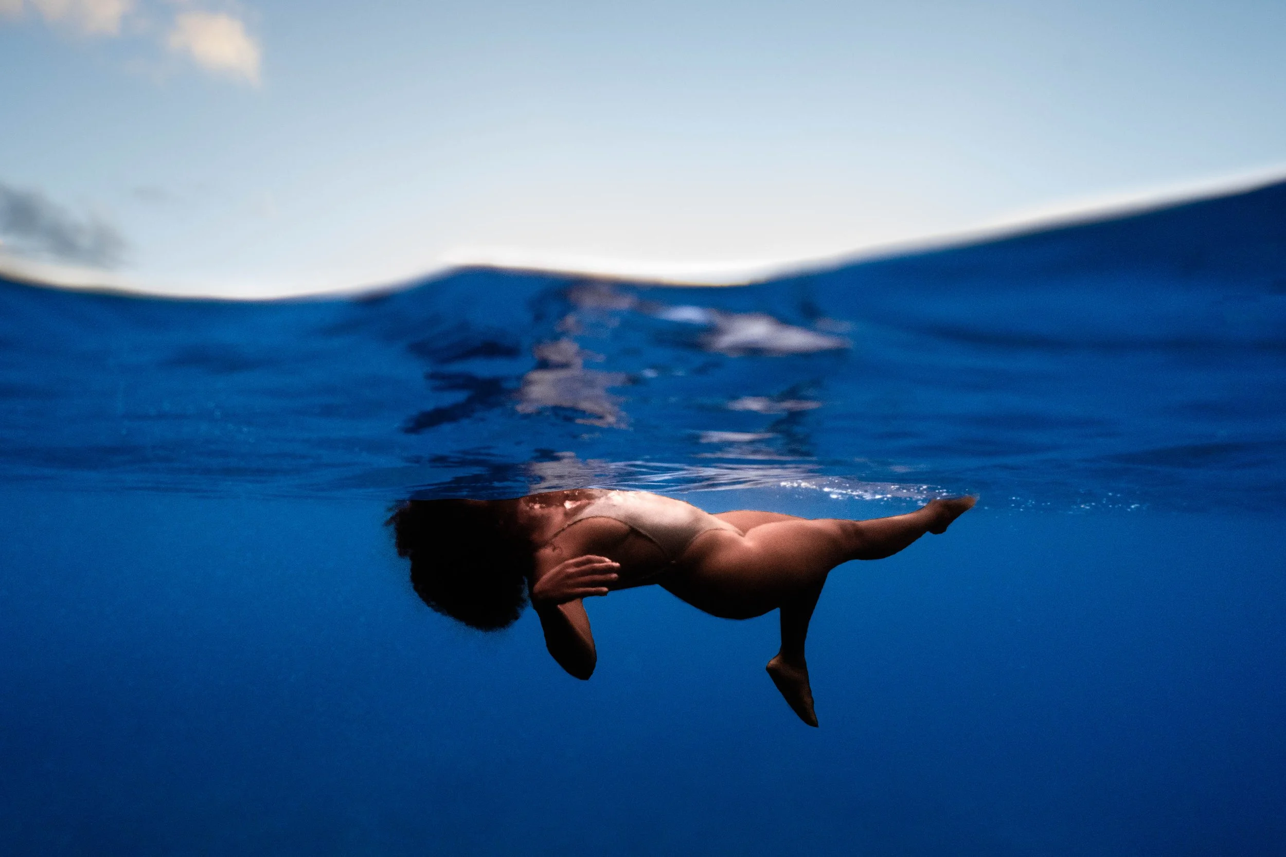 Woman swimming underwater viewed from beneath the surface