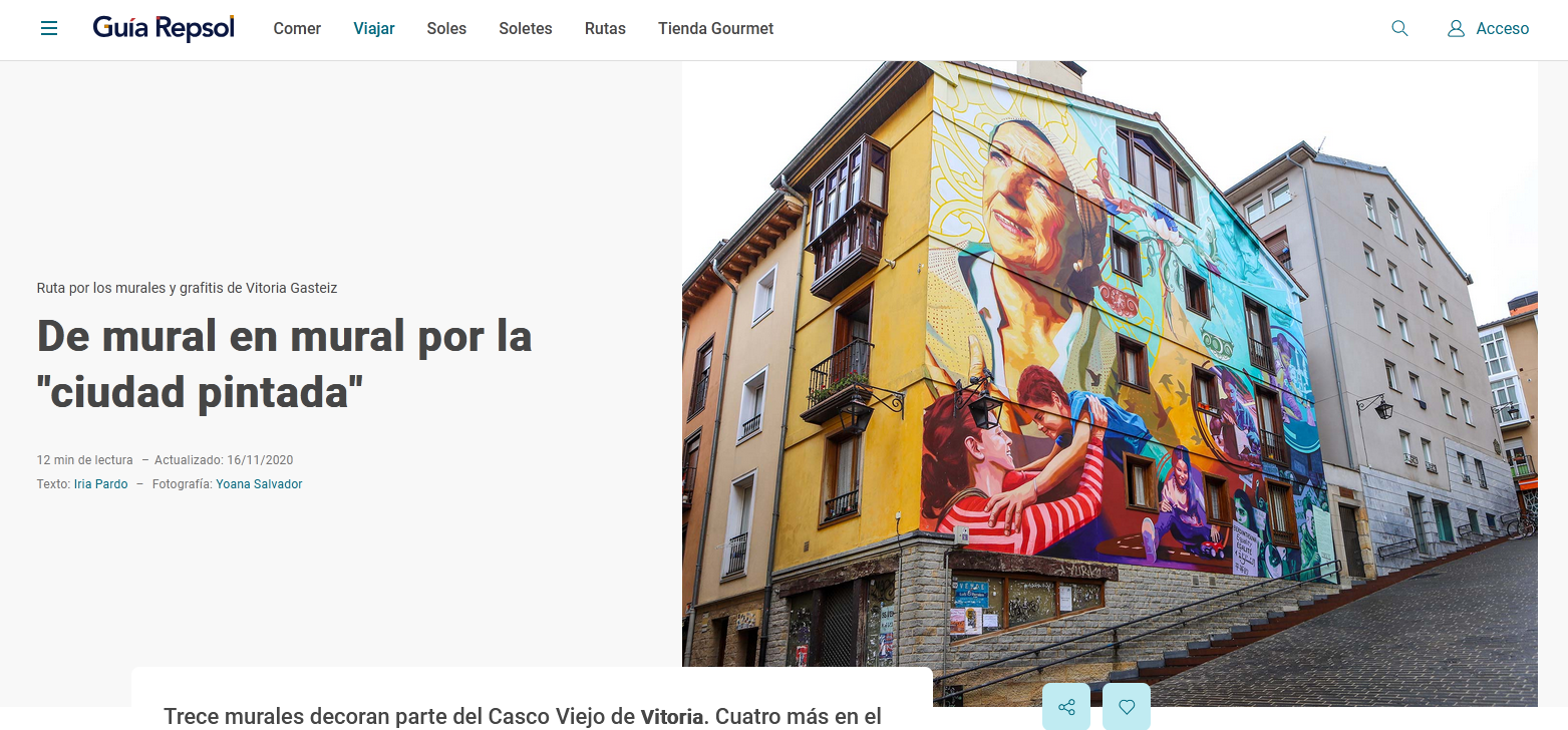 Colorful mural on the side of a building in Vitoria city depicting joyful women, a senior woman with glasses smiling, and abstract artistic elements.