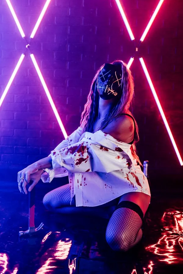 A cinematic color-gel neon boudoir portrait in deep shadow