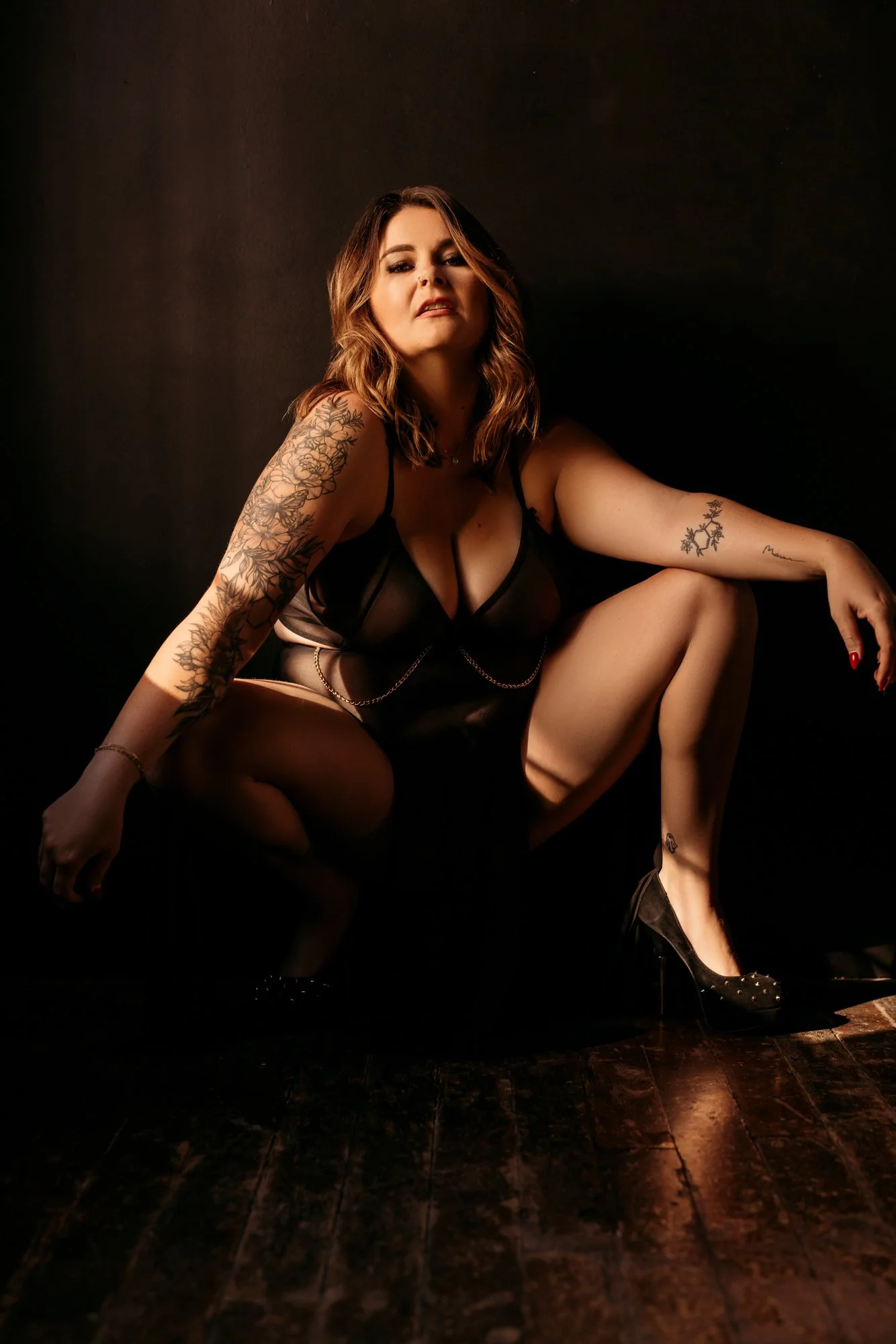 a woman in black lingerie posing in harsh light 