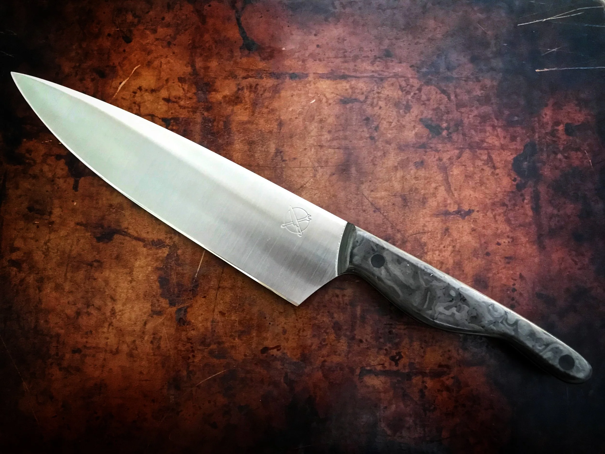 The Mule — 8" Chef's Knife in AEB-L | USA Made Aerospace Grade Shredded Carbon Fiber Scales | Solid ¼" Carbon Fiber Pins — SOLD | Standard carbon fiber is predictable. This isn't. Aerospace grade material with a shredded, marbled weave pattern — no t