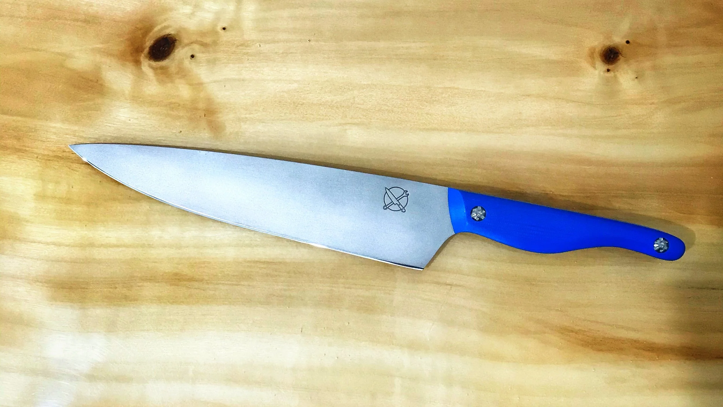 A kitchen knife with a stainless steel blade and a blue handle on a wooden surface.