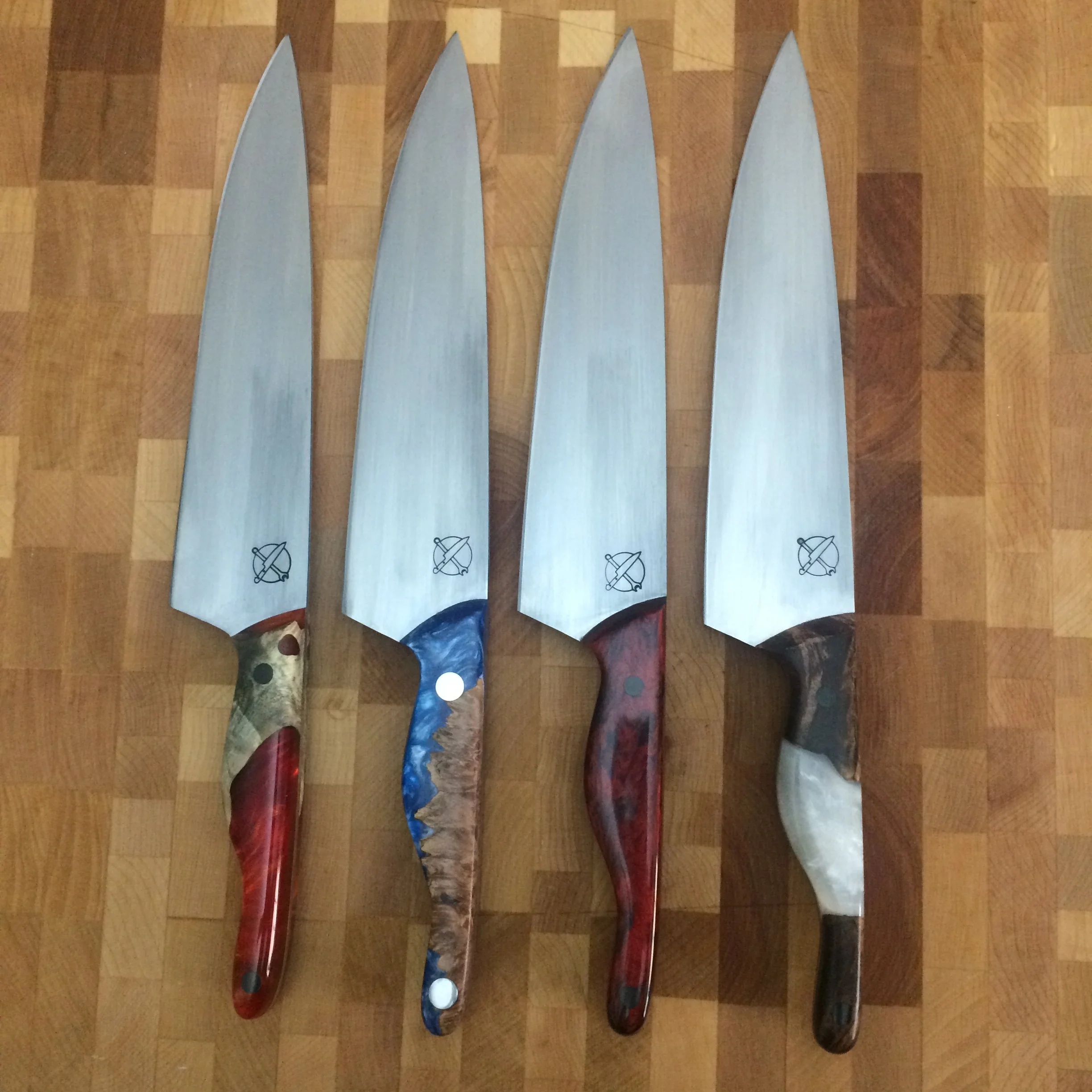 Four Mules — 8" Chef's Knives in AEB-L | No Two Handles Alike — SOLD | The last family photo before they went their separate ways. Four knives built side by side in the same 80 sq ft shop at the same time — same steel, same hands, four completely dif