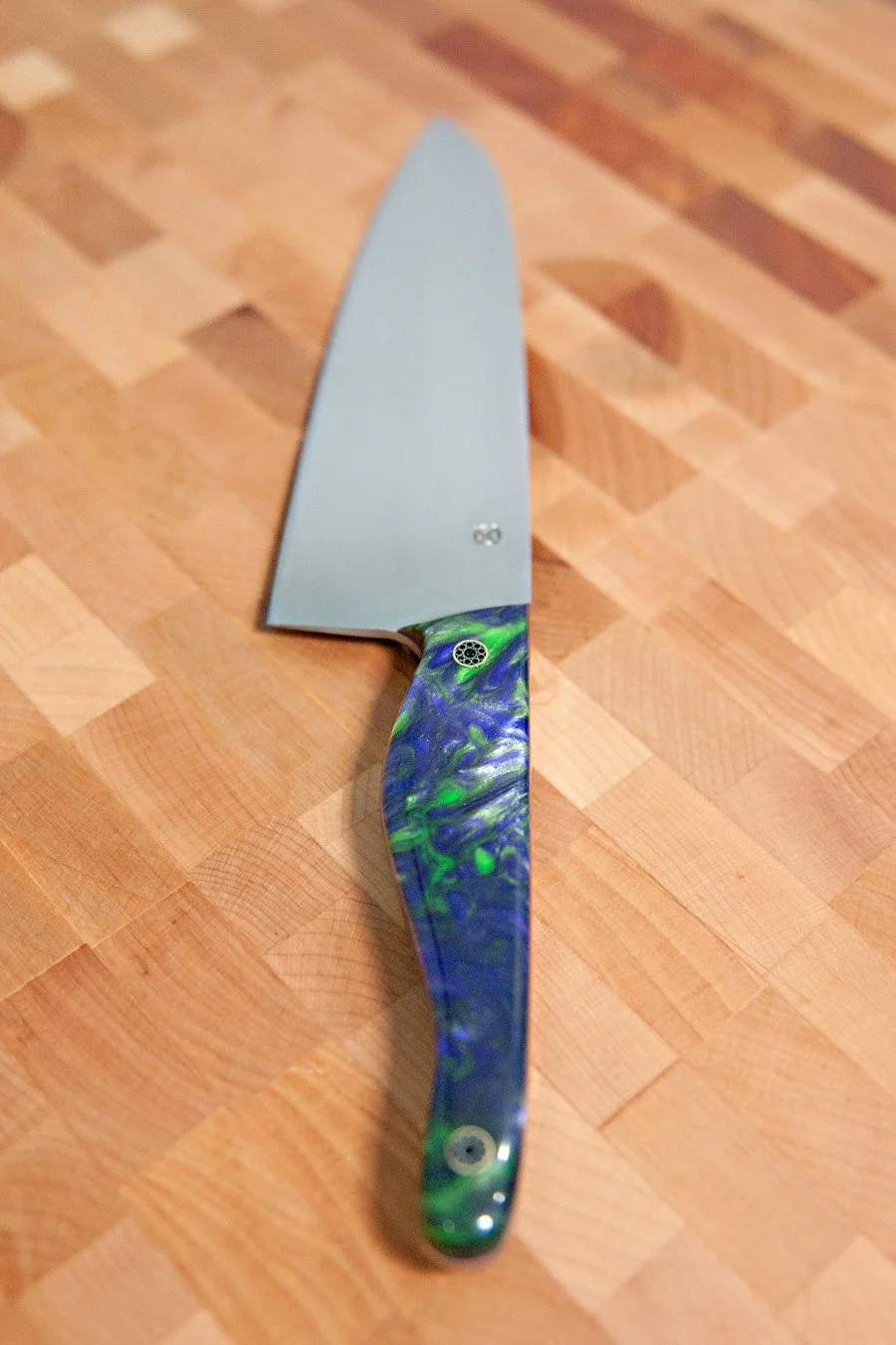 Kitchen knife with a colorful, swirled handle on a wooden cutting board