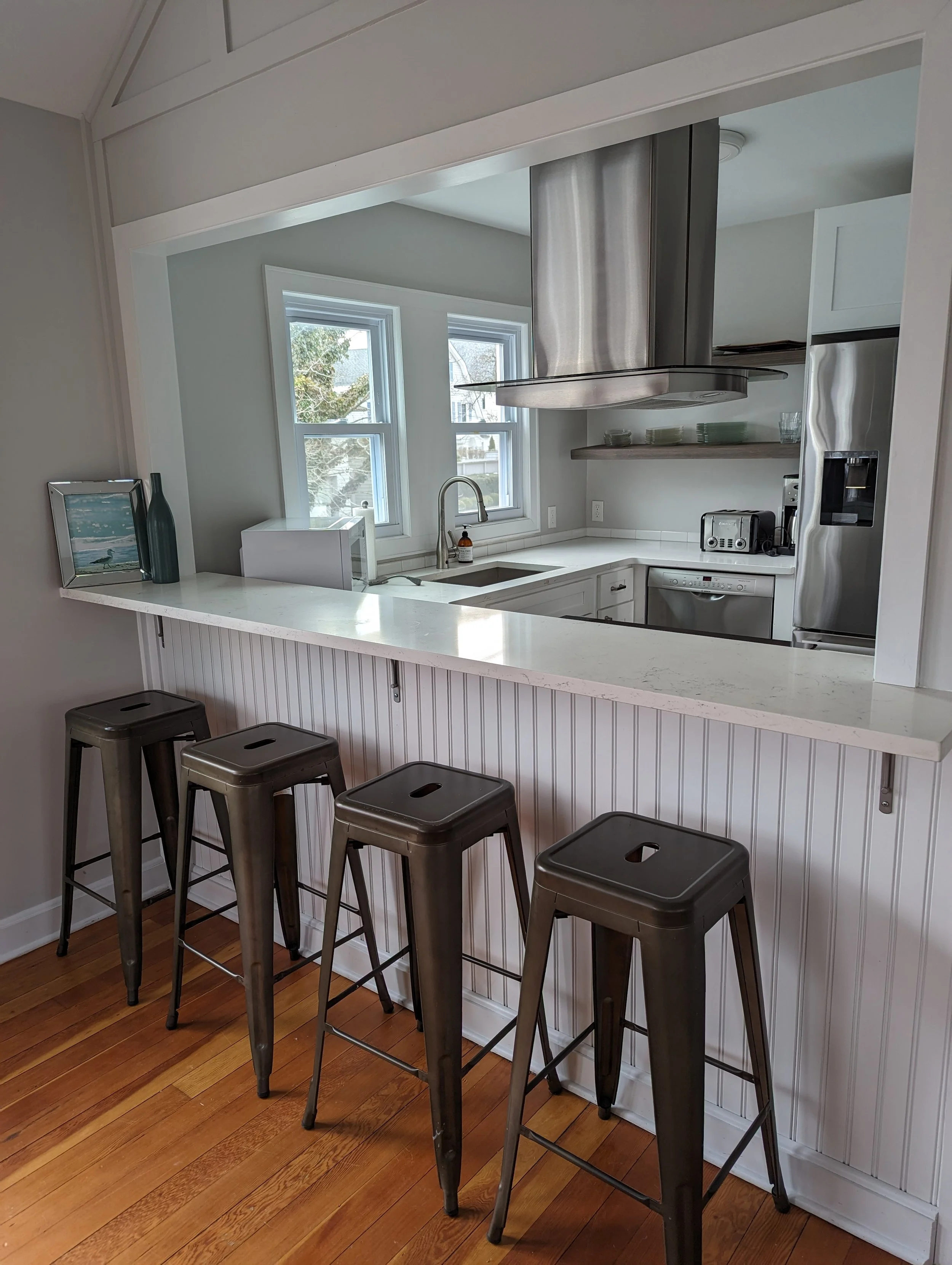 kitchen opens to dining room with stools