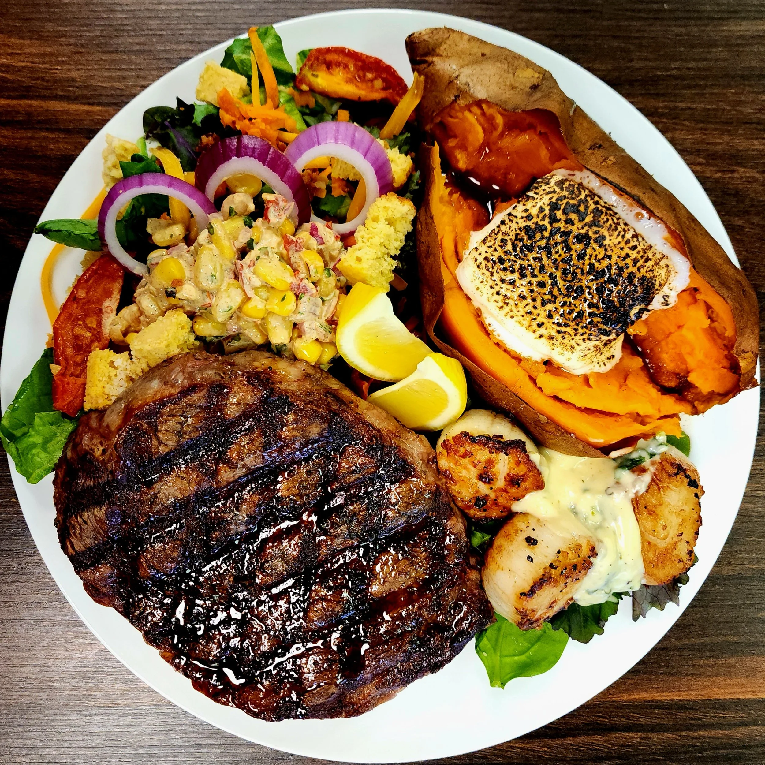 14oz Gunpowder Ribeye with Pan Seared Scallops, a Souffled Sweet Potato, & our South x Southwest Salad.